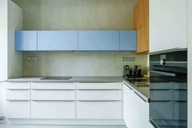 Modrobílá kuchyně s šedou stěrkou