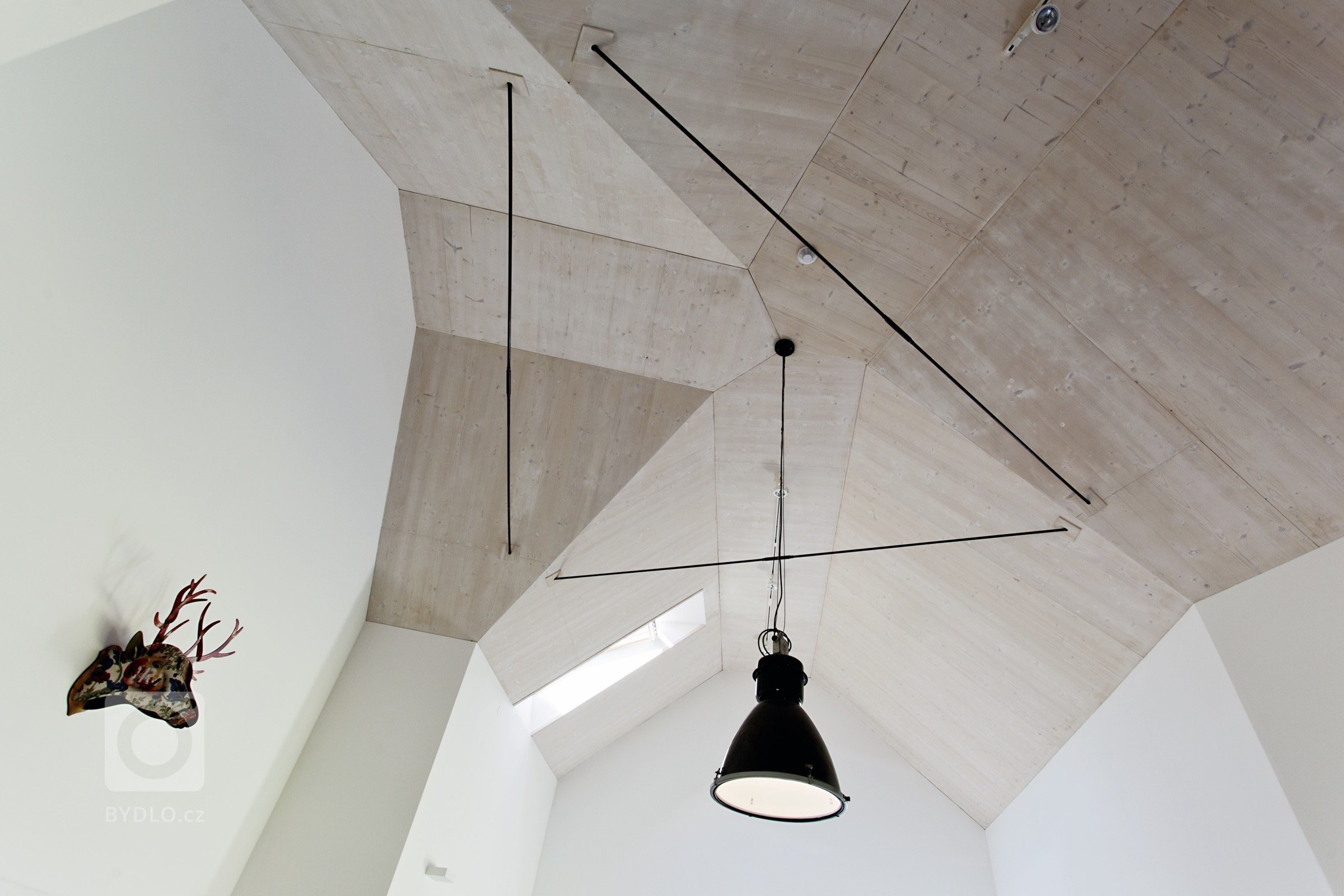 Rodinný dům v malé obci Pstruží na Moravě se svým půdorysným řešením vymyká běžným stavením vesnického typu se sedlovou střechou. Jeho uzpůsobení totiž vyplývá…