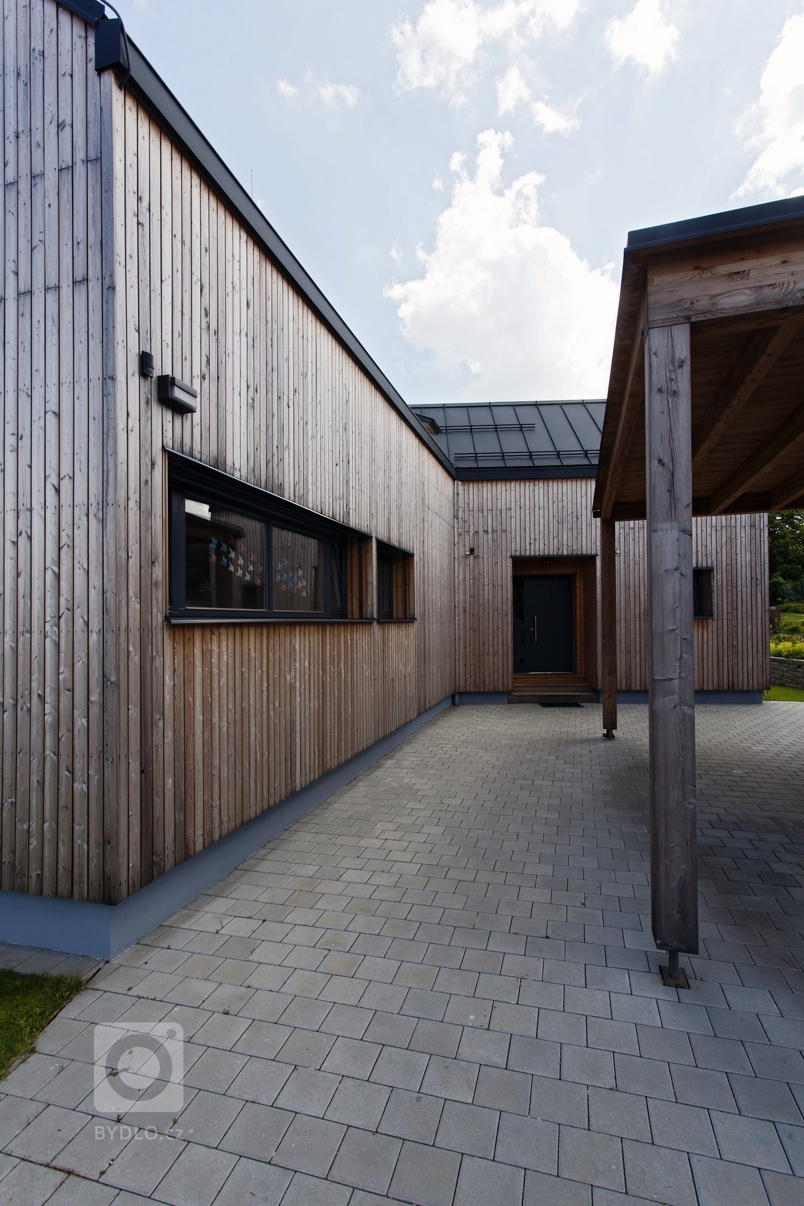 Rodinný dům v malé obci Pstruží na Moravě se svým půdorysným řešením vymyká běžným stavením vesnického typu se sedlovou střechou. Jeho uzpůsobení totiž vyplývá…