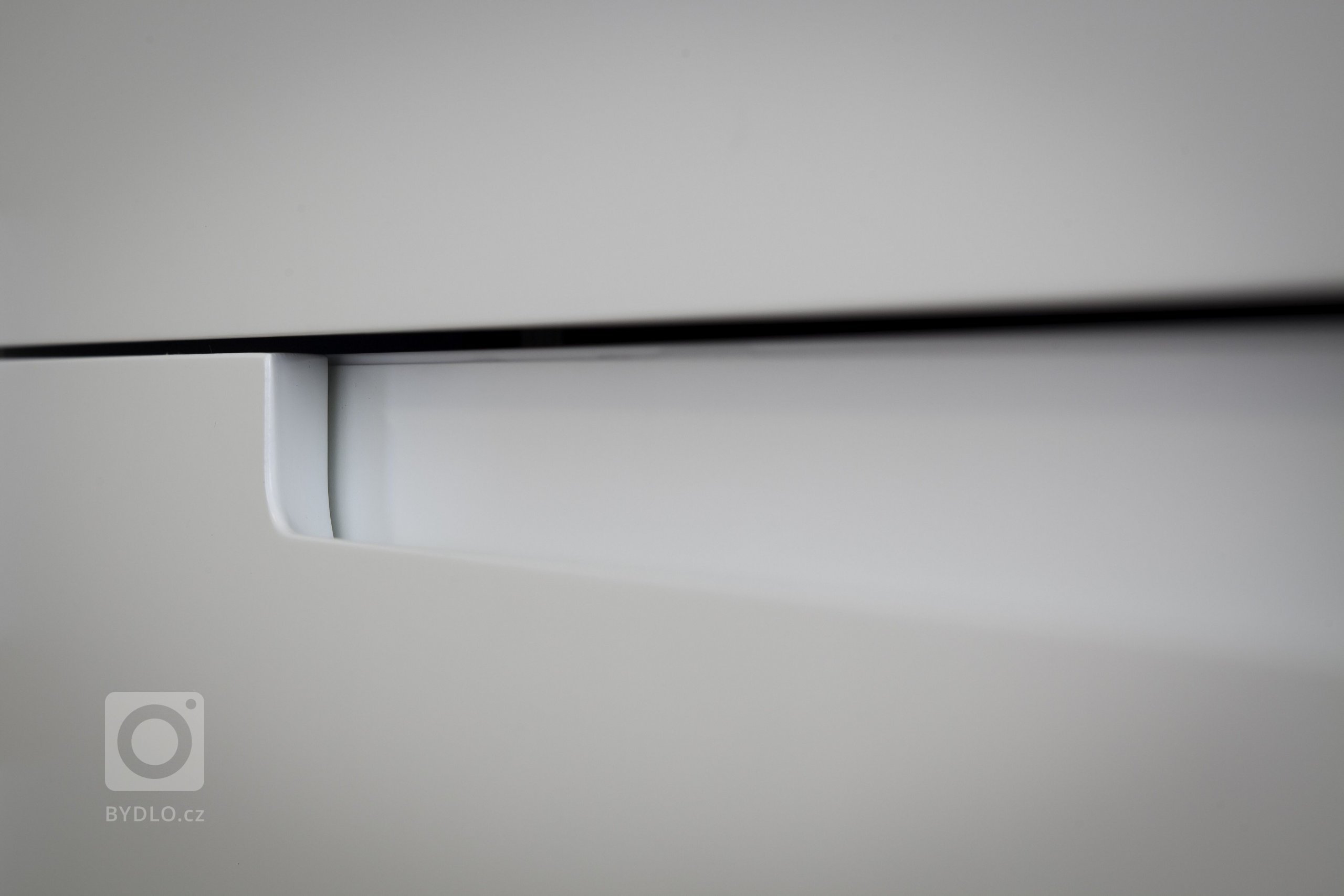 Kuchyňská linka s&nbsp;velkorysým ostrůvkem z materiálu Corian. Netradičním prvkem kuchyně je uzavíratelná část linky, díky které bude kuchyň vypadat uklizeně…