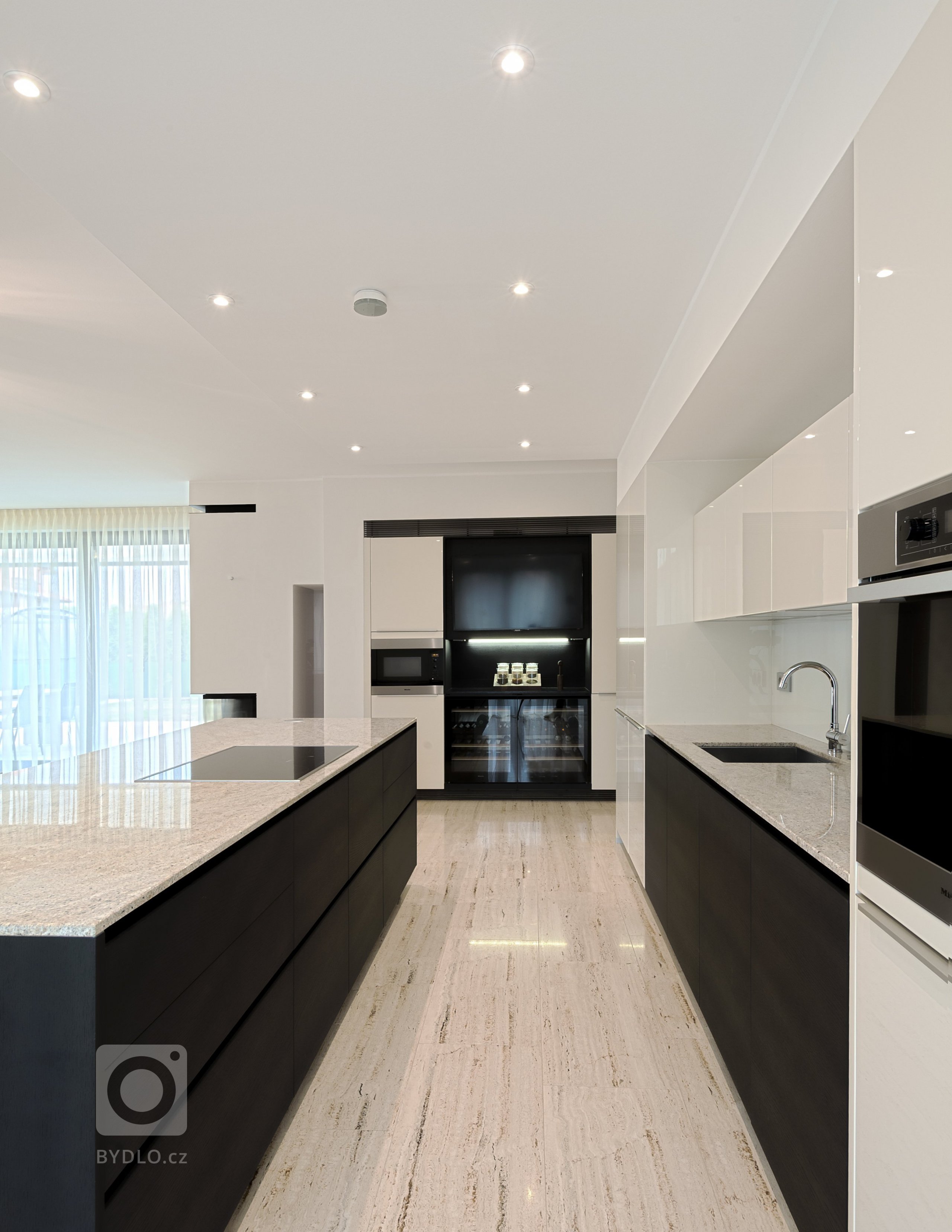 Kuchyně v kombinaci smetanový lak a kouřový dub. Podlahy z přírodního travertinu.