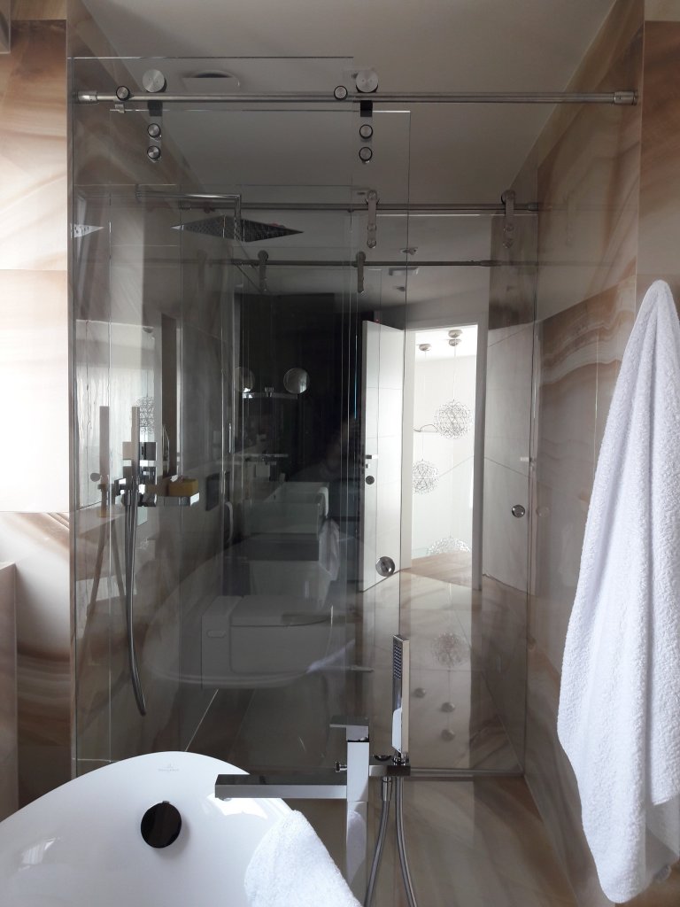 Koupelna se skleněnými dělícími stěnami.