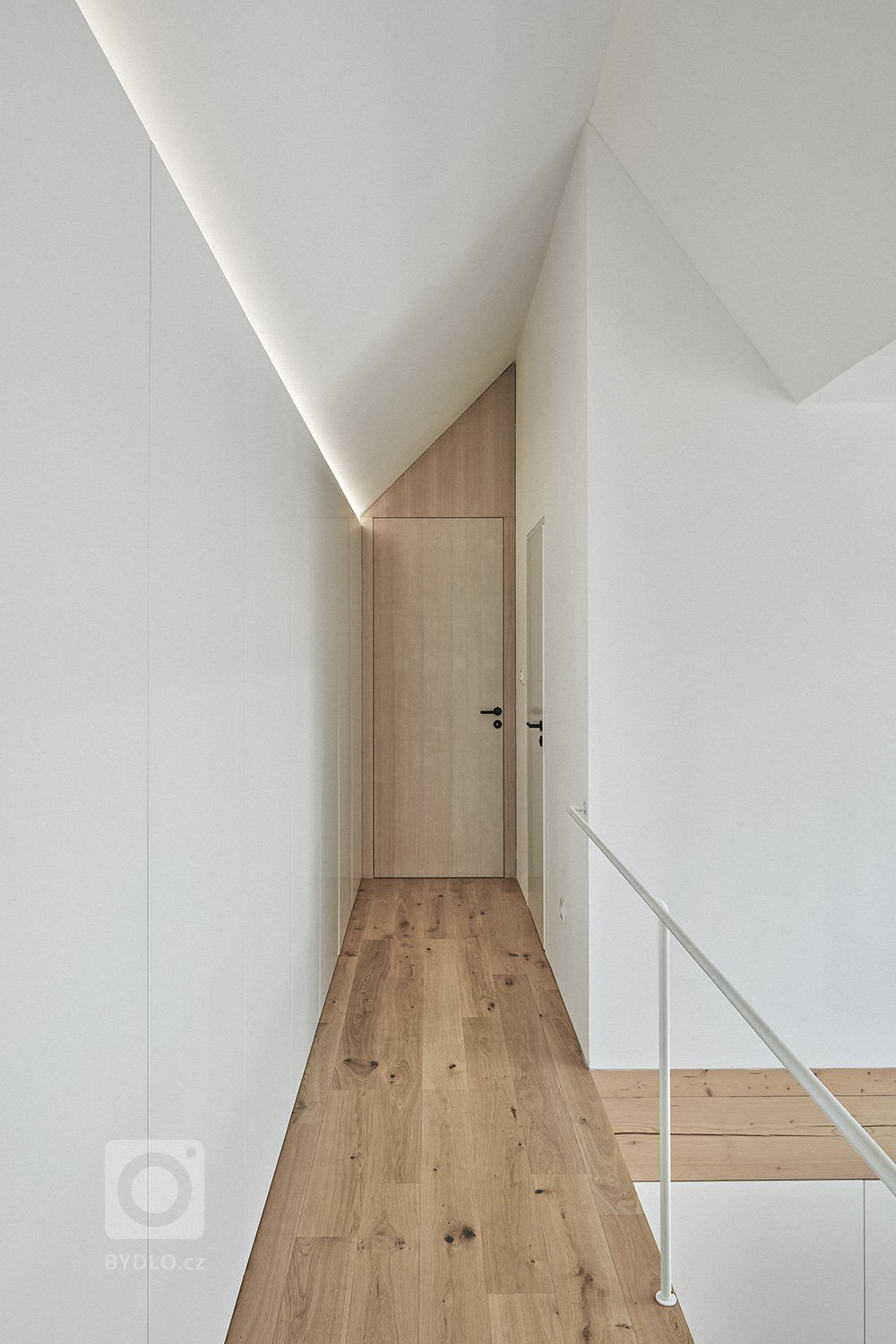 Pozemek leží na hraně svahu v&nbsp;centru malé obce na Vysočině. Na půdorysné stopě bývalého statku vznikl dům a stodola. Dům má podél jihozápadní fasády kryté…