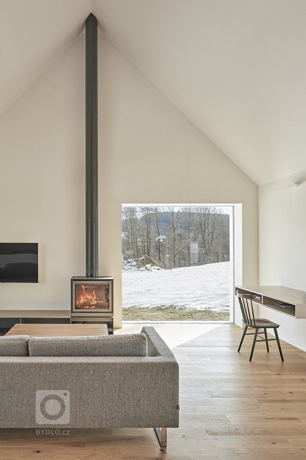 Pozemek leží na hraně svahu v&nbsp;centru malé obce na Vysočině. Na půdorysné stopě bývalého statku vznikl dům a stodola. Dům má podél jihozápadní fasády kryté…