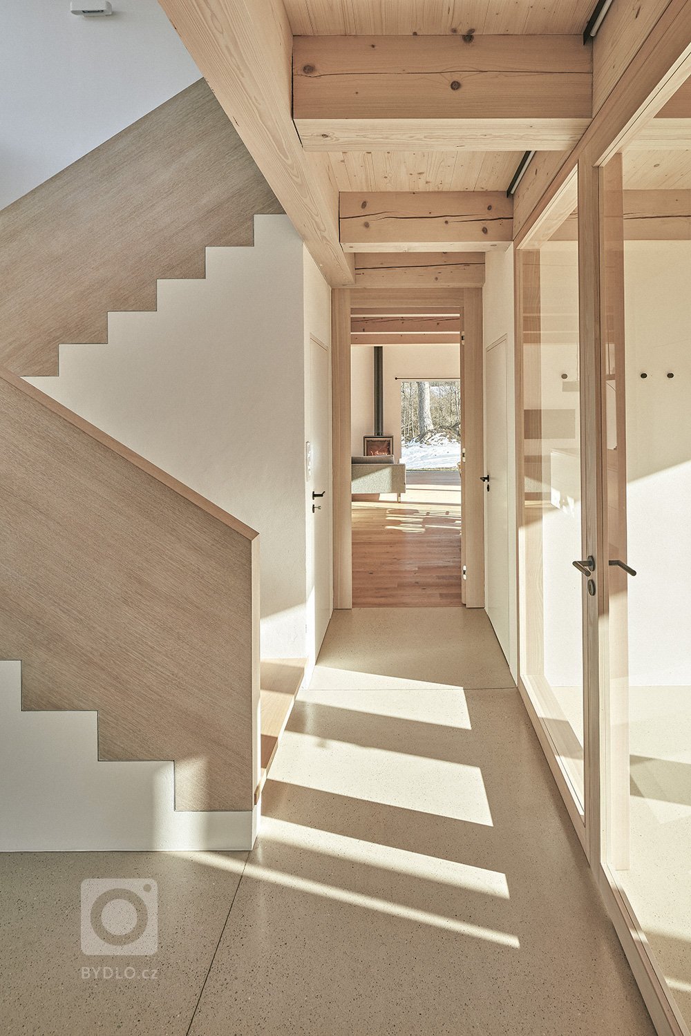 Pozemek leží na hraně svahu v&nbsp;centru malé obce na Vysočině. Na půdorysné stopě bývalého statku vznikl dům a stodola. Dům má podél jihozápadní fasády kryté…