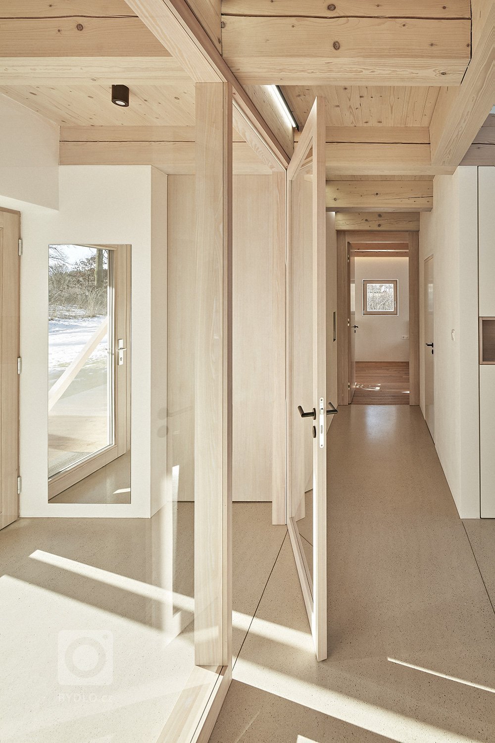 Pozemek leží na hraně svahu v&nbsp;centru malé obce na Vysočině. Na půdorysné stopě bývalého statku vznikl dům a stodola. Dům má podél jihozápadní fasády kryté…