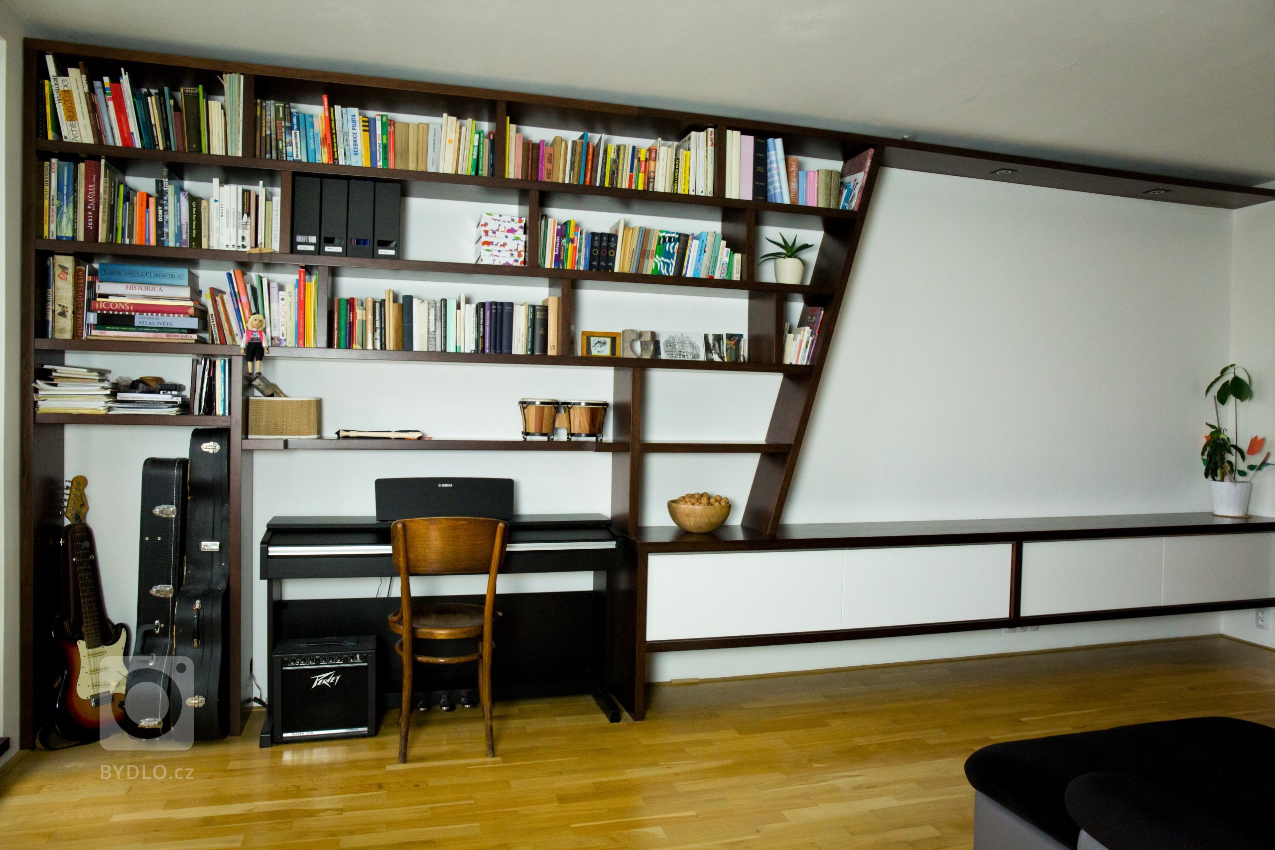 Obývací stěna ukrývá hudební kout, knihovnu i promítací plochu