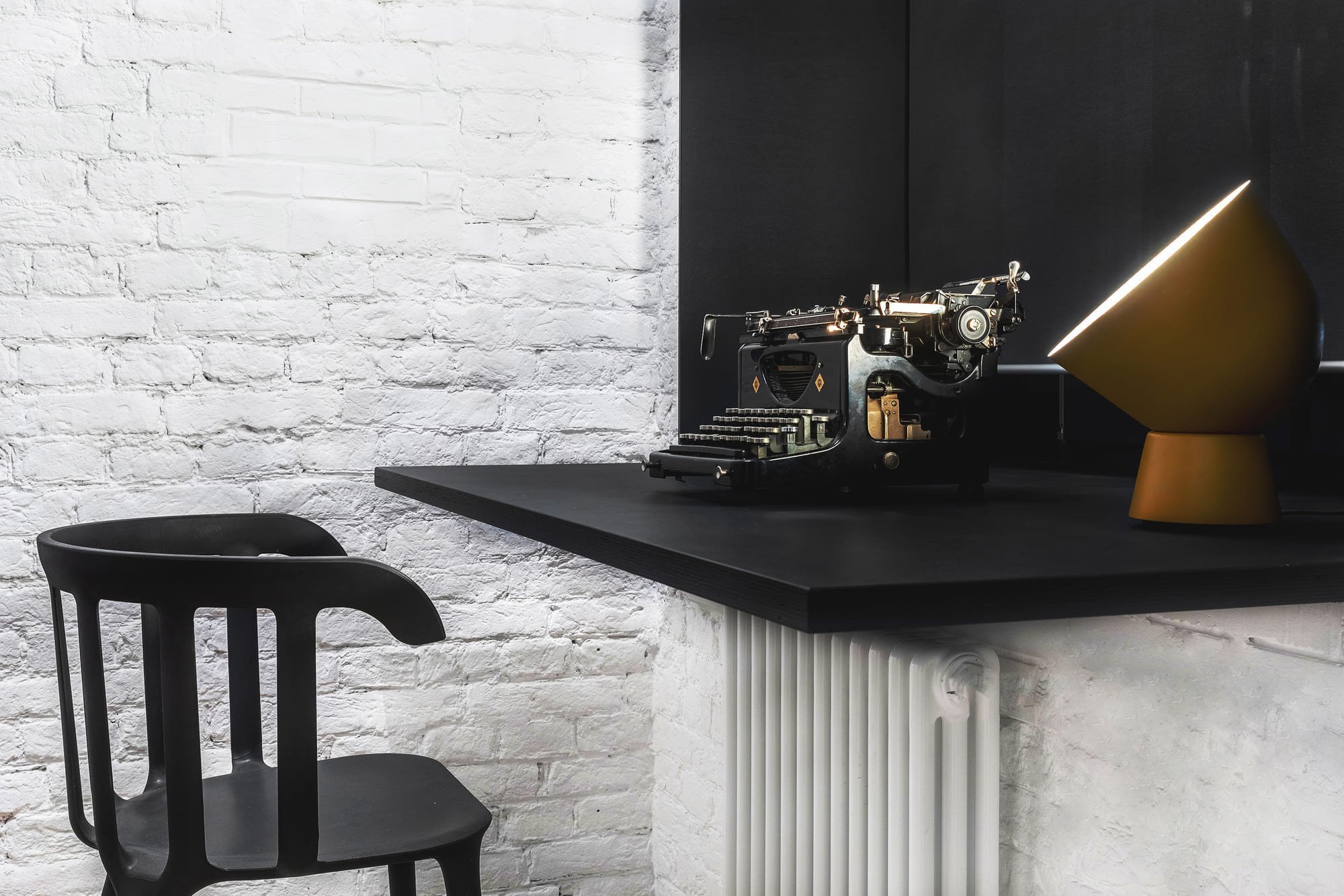 Byt s nábytkem IKEA a černou cihlovou zdí