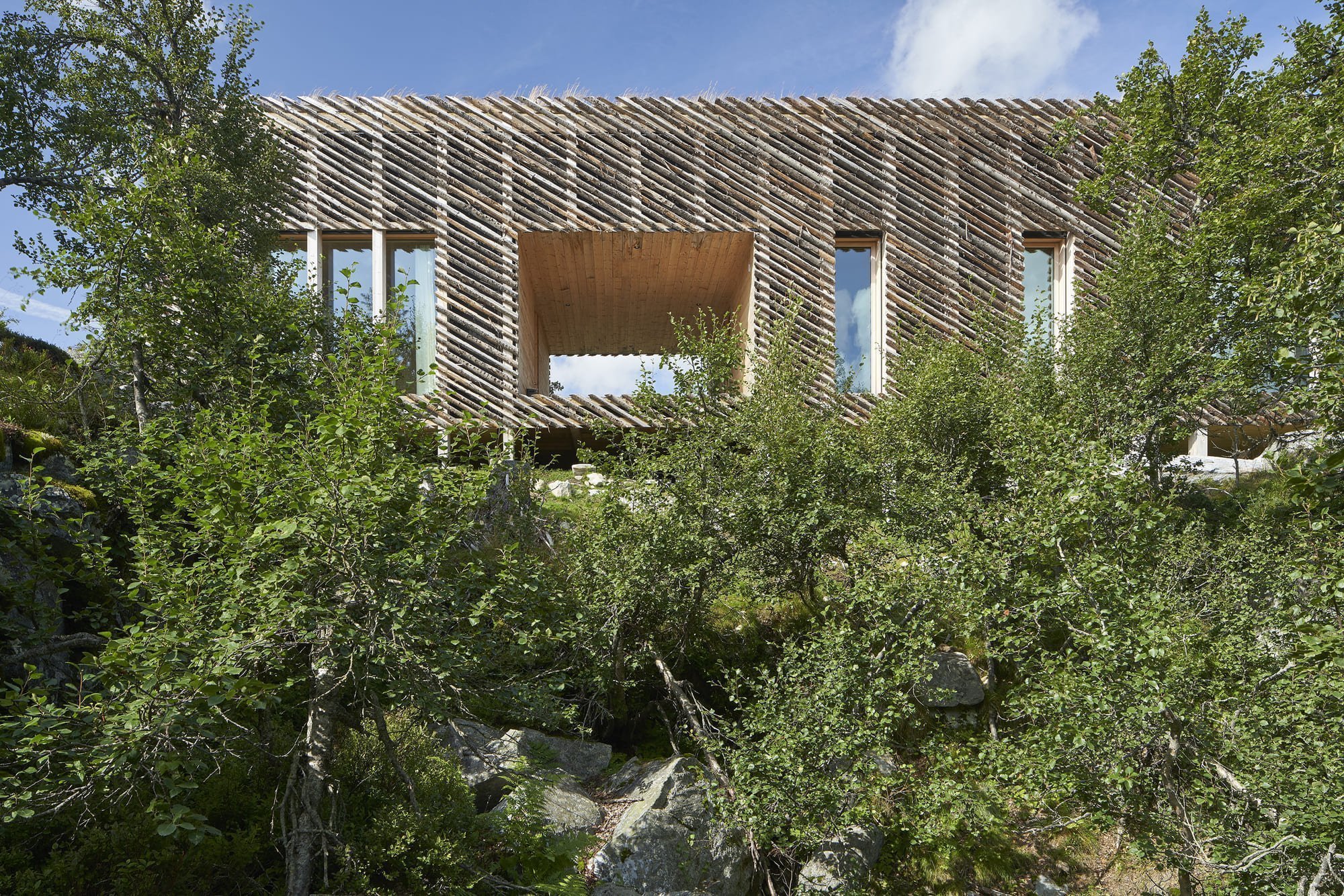 Chata zabalená plotem odolává drsným podmínkám na vrcholku hory