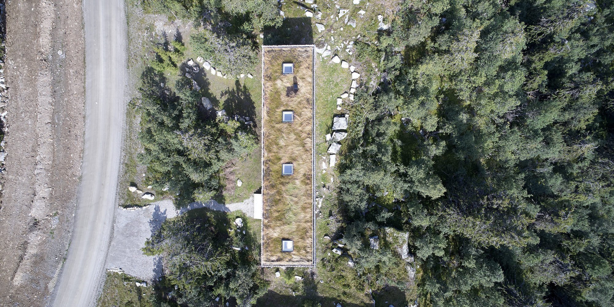 Chata zabalená plotem odolává drsným podmínkám na vrcholku hory