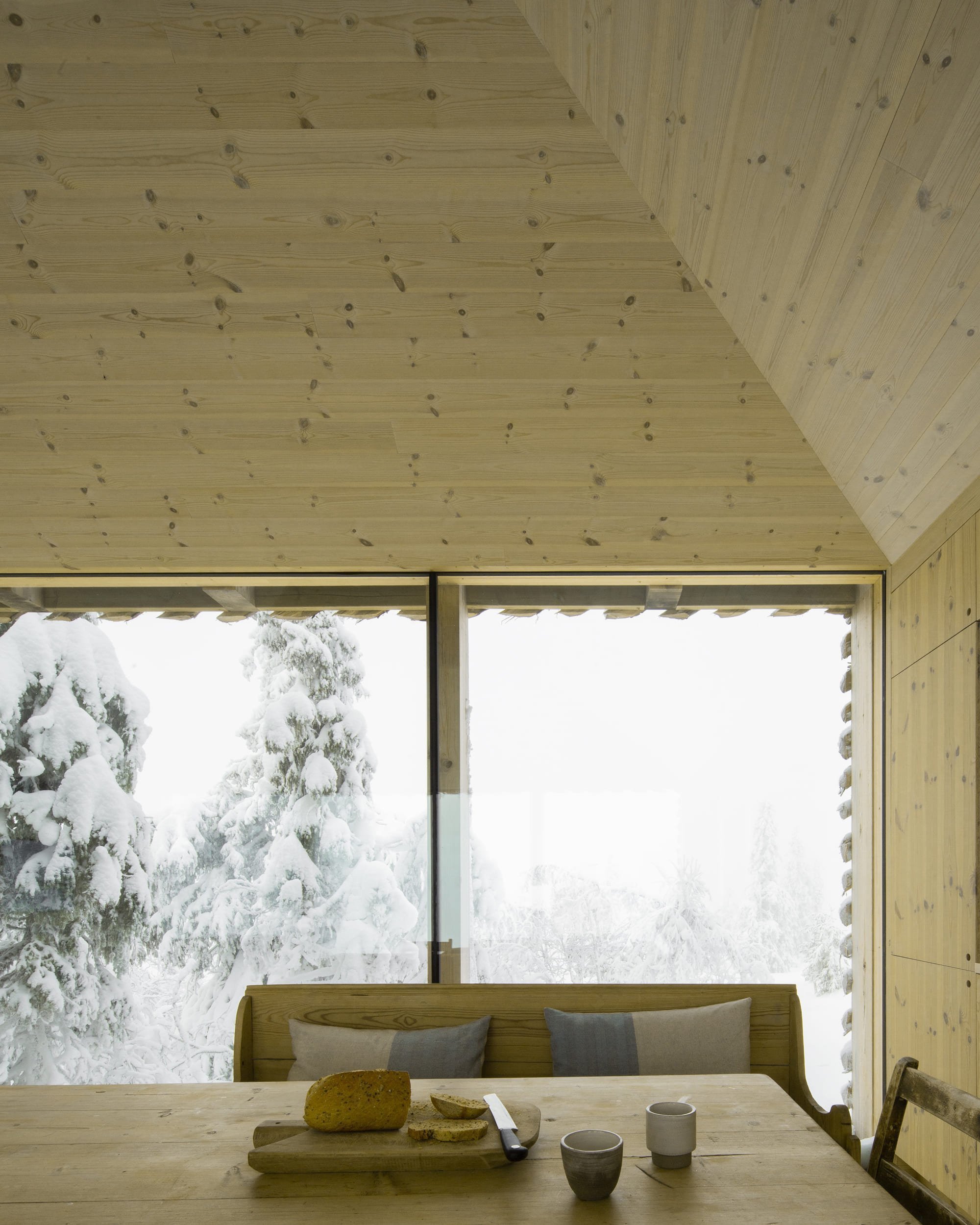 Chata zabalená plotem odolává drsným podmínkám na vrcholku hory