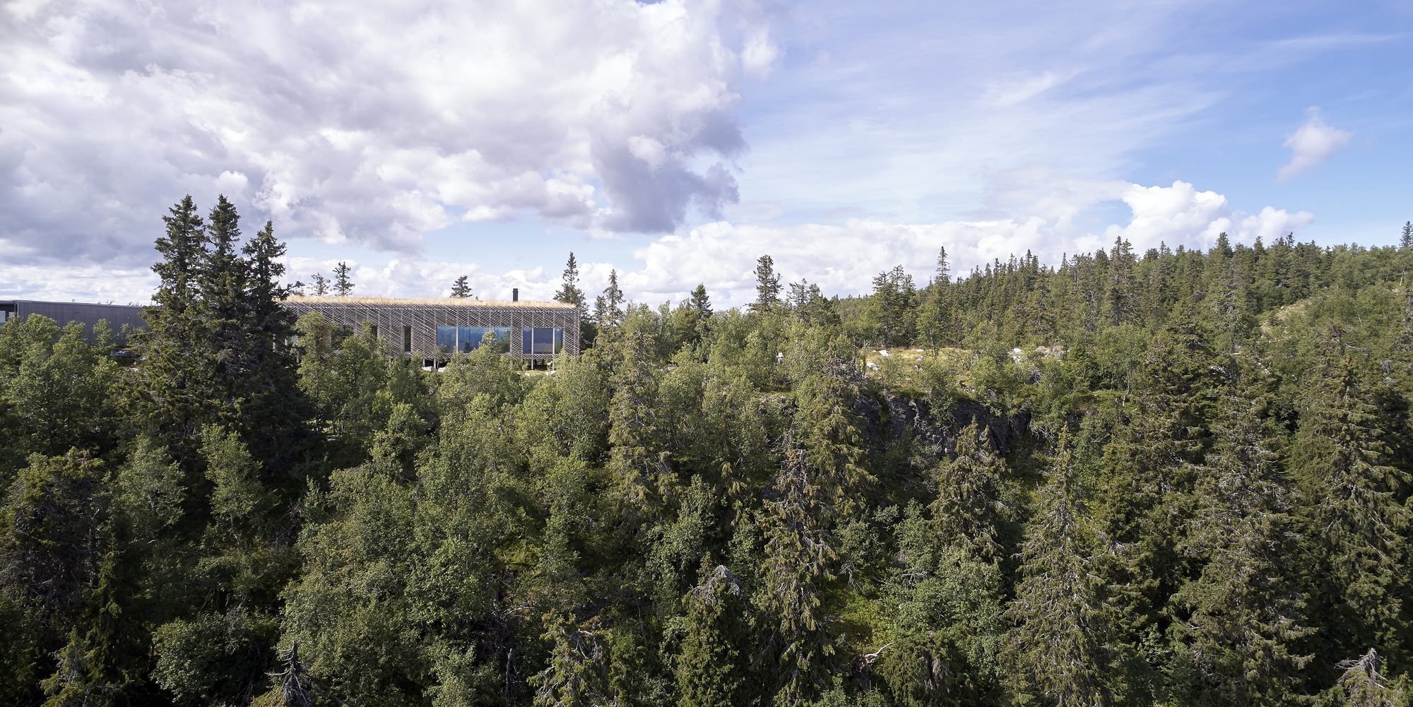 Chata zabalená plotem odolává drsným podmínkám na vrcholku hory