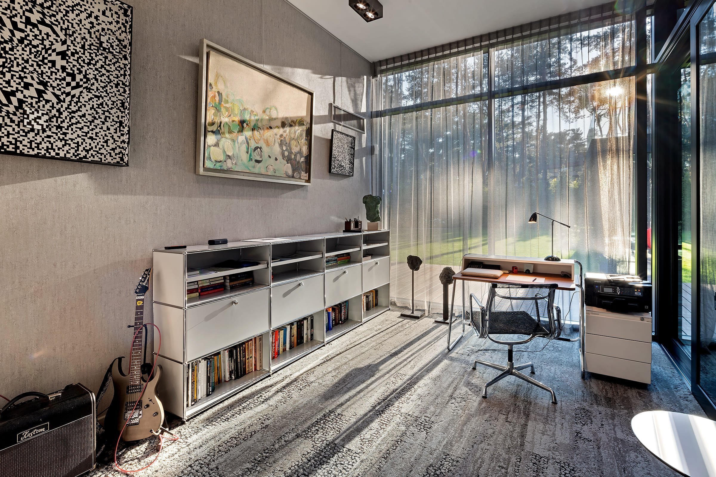 Dům s betonovou fasádou obklopený lesy