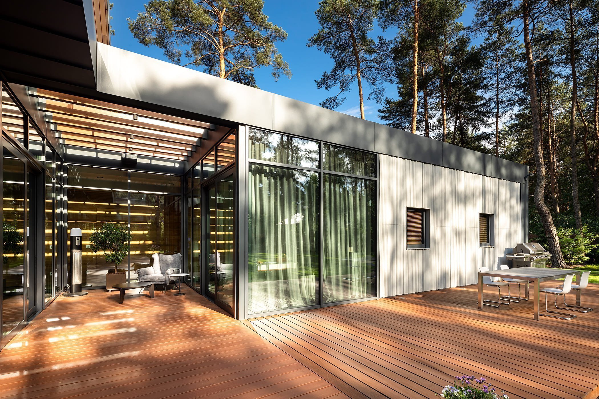 Dům s betonovou fasádou obklopený lesy