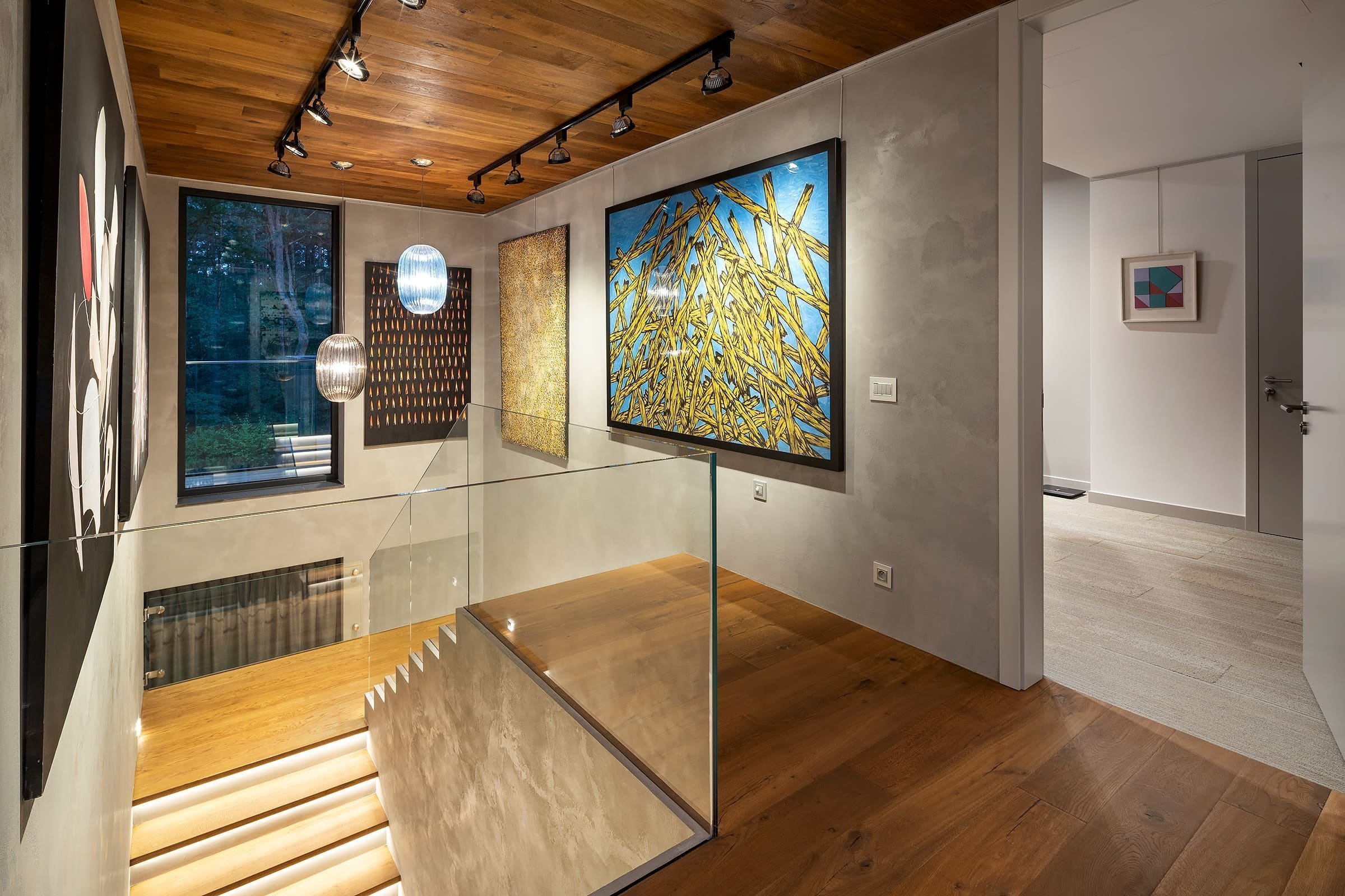 Dům s betonovou fasádou obklopený lesy