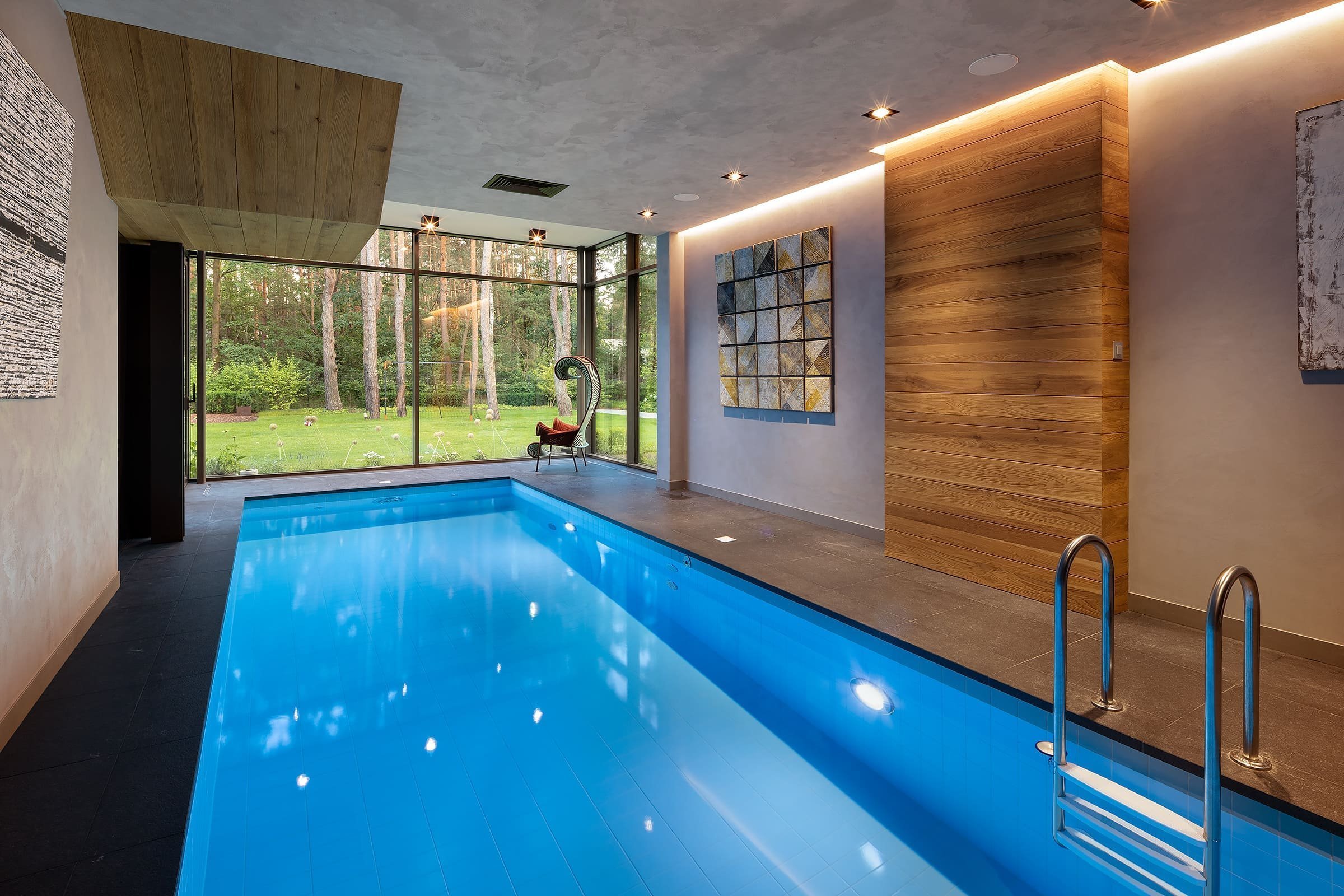 Dům s betonovou fasádou obklopený lesy