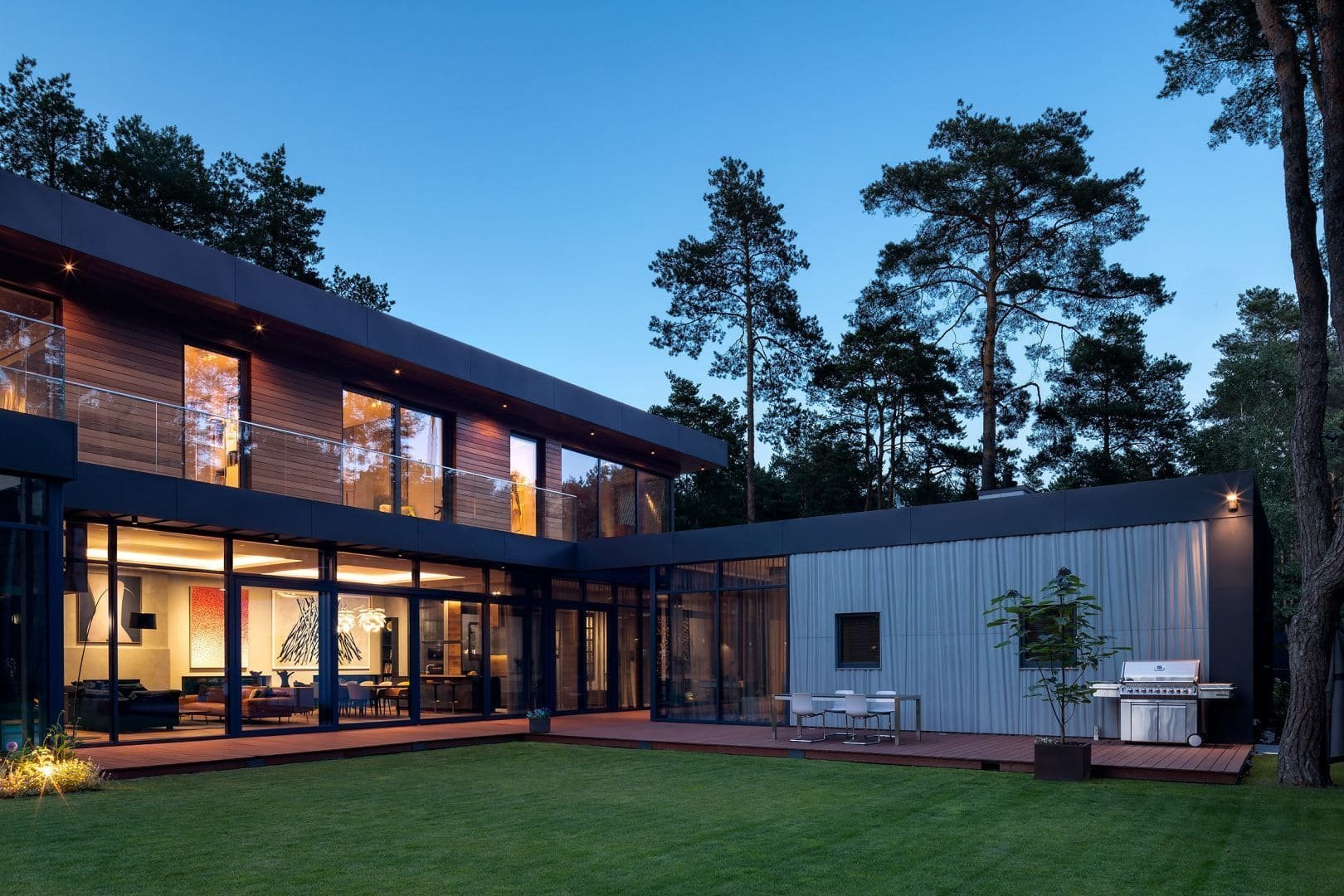 Dům s betonovou fasádou obklopený lesy