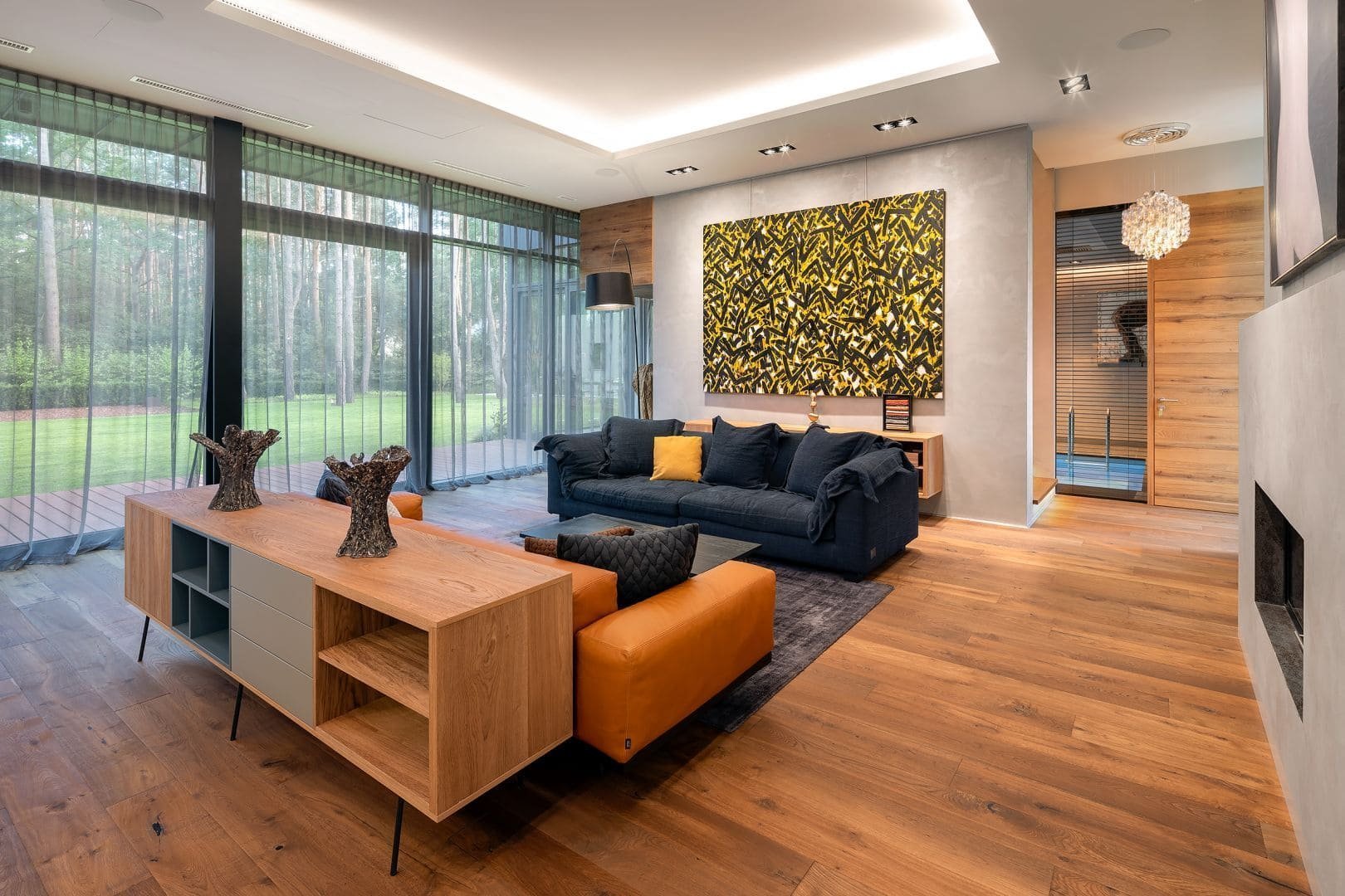 Dům s betonovou fasádou obklopený lesy