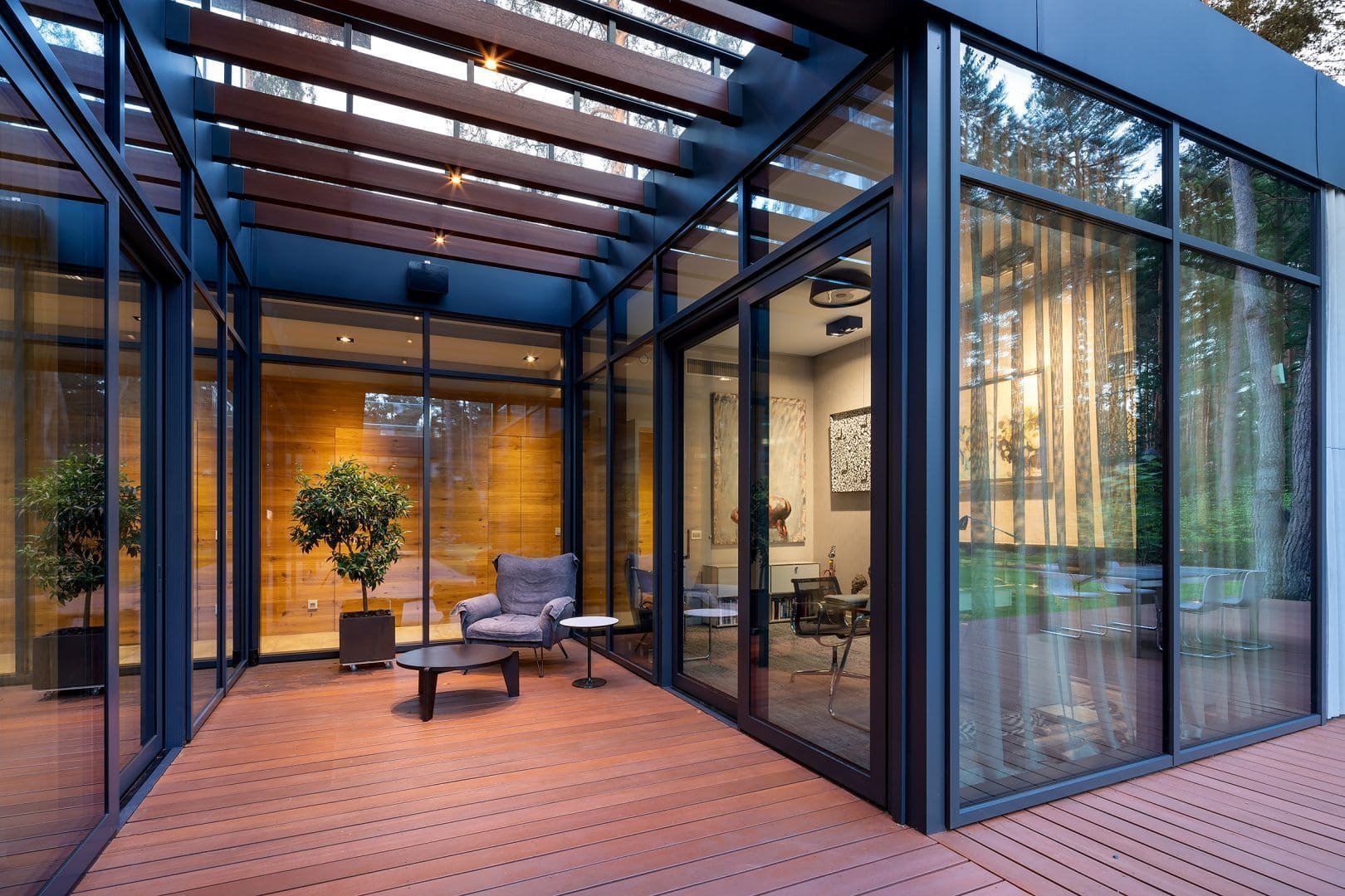 Dům s betonovou fasádou obklopený lesy