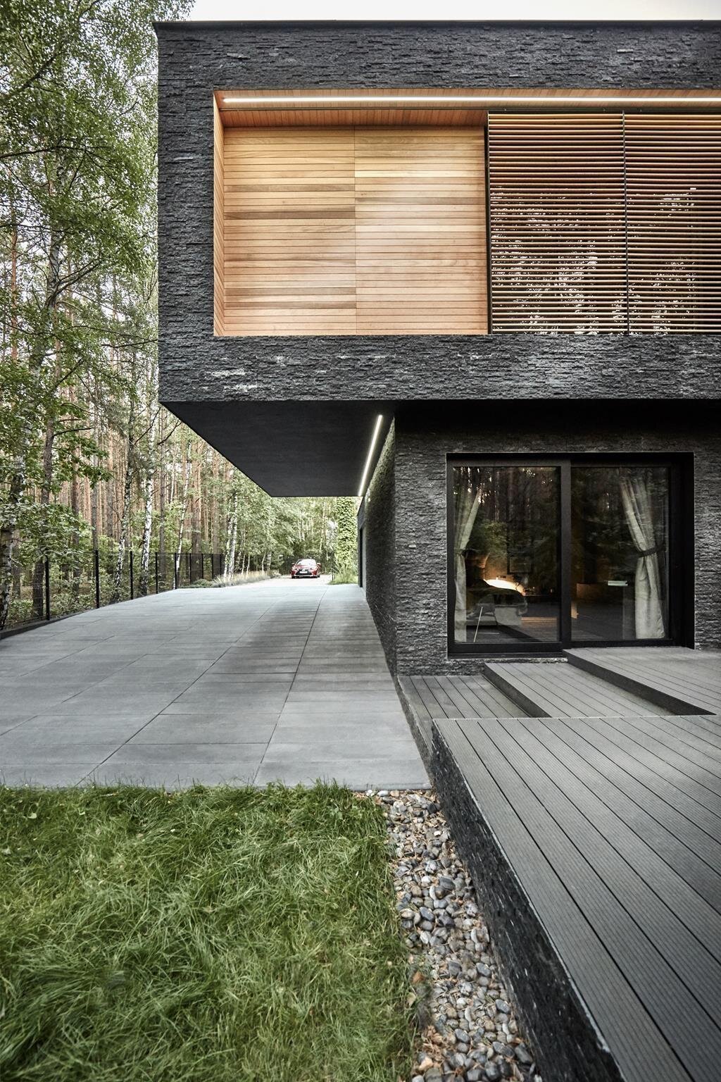 Dům s fasádou z břidlice uprostřed lesa