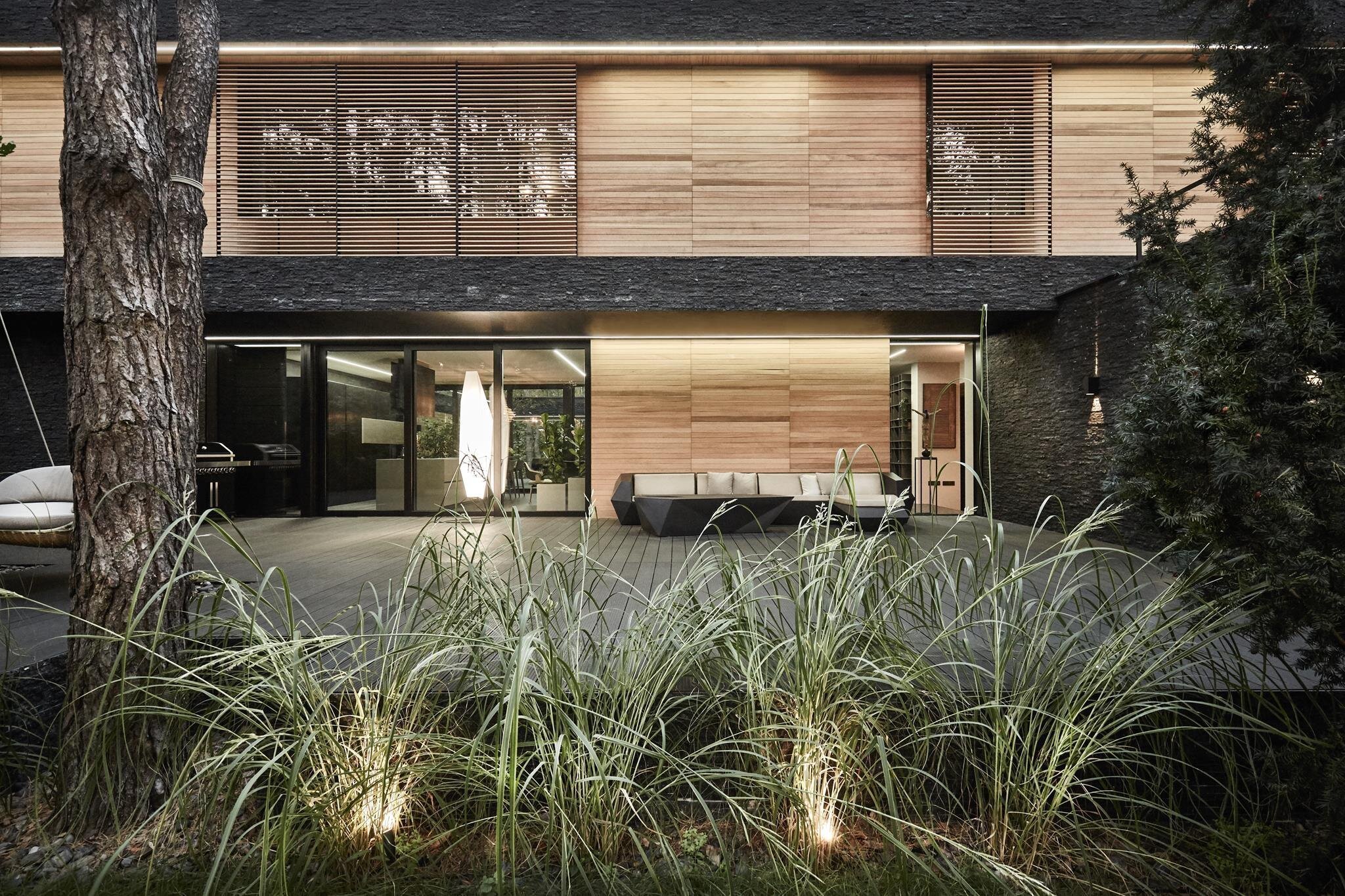 Dům s fasádou z břidlice uprostřed lesa