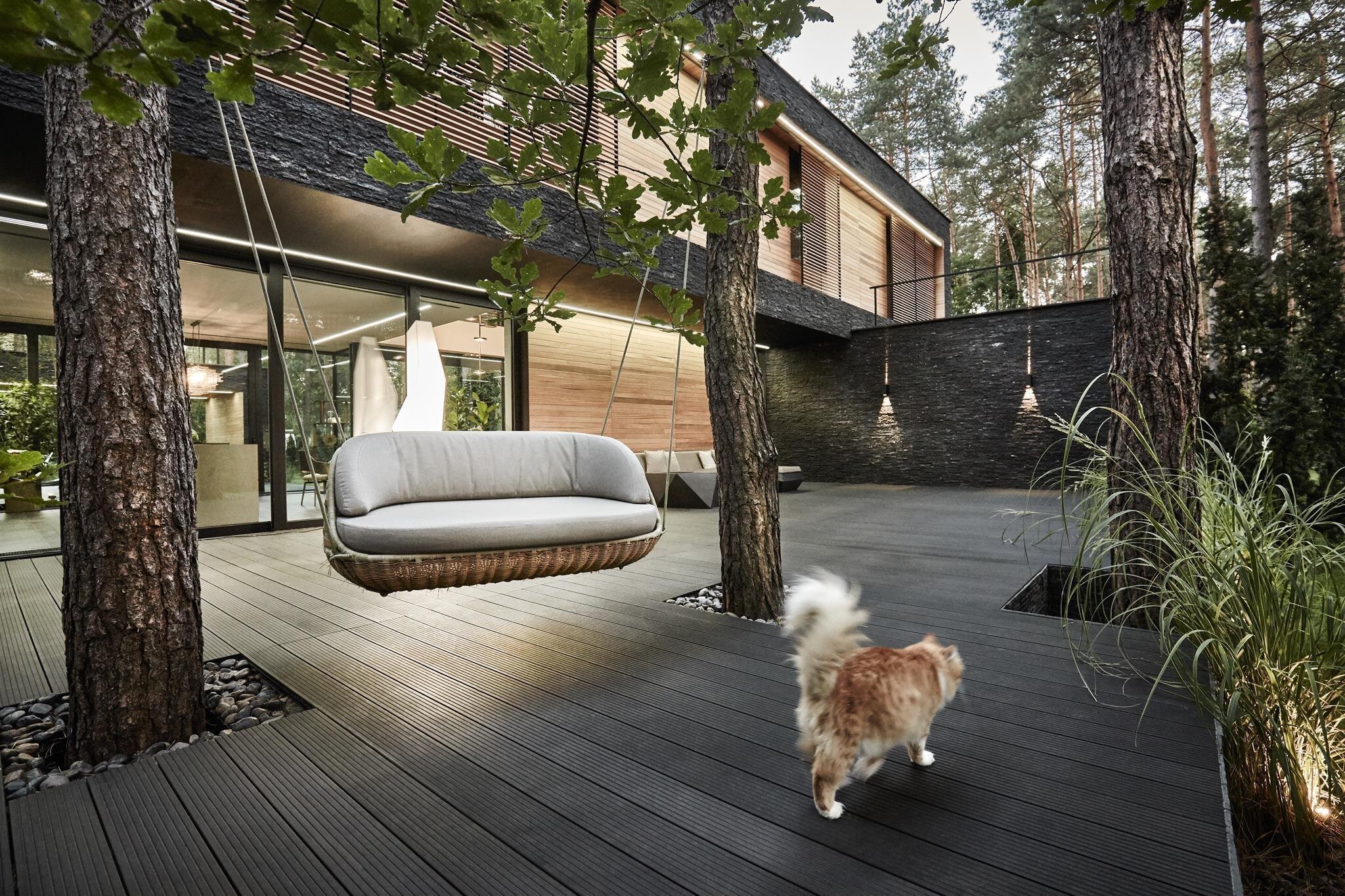 Dům s fasádou z břidlice uprostřed lesa