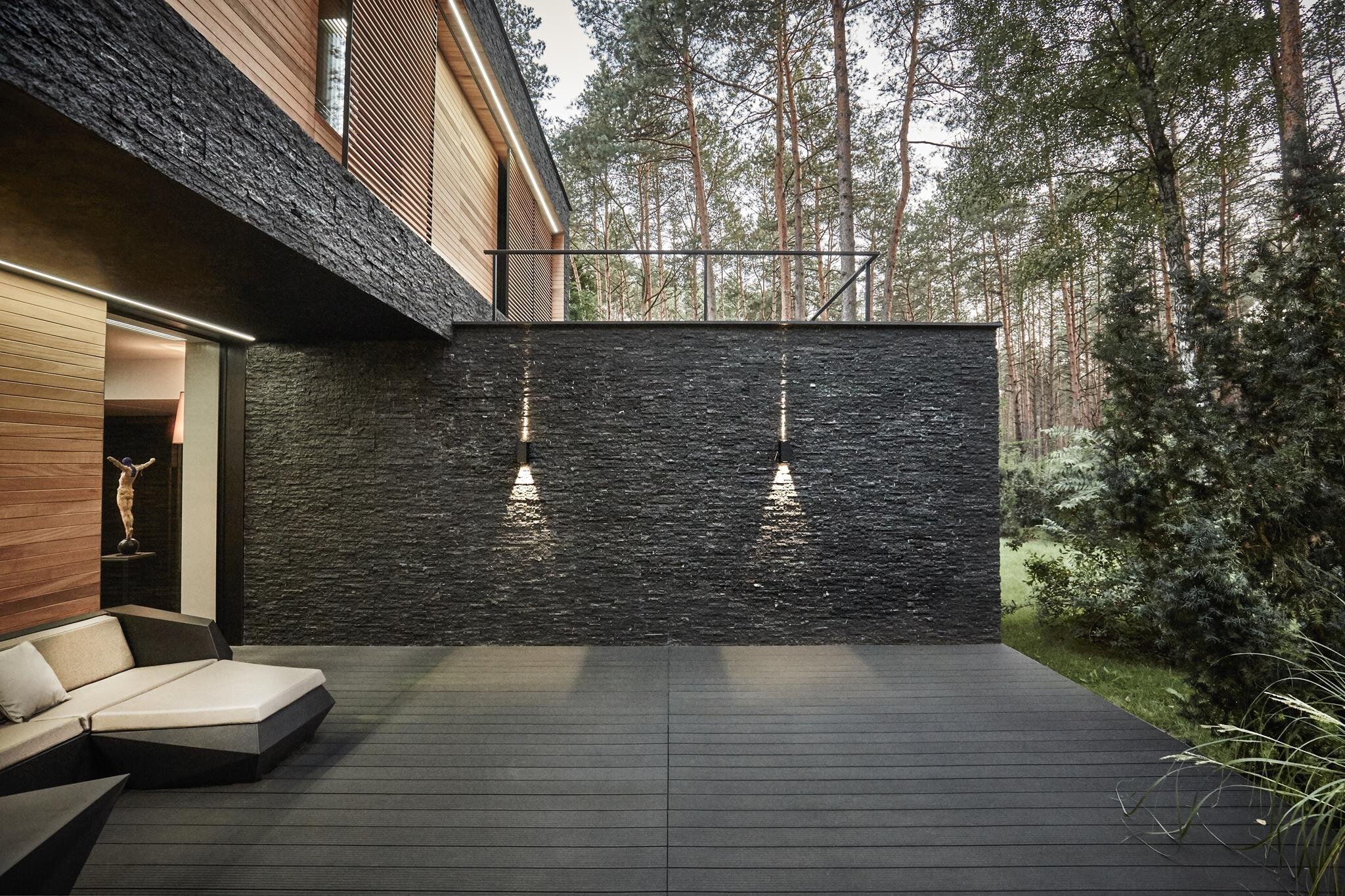 Dům s fasádou z břidlice uprostřed lesa