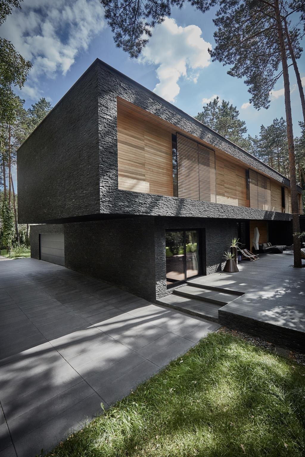 Dům s fasádou z břidlice uprostřed lesa