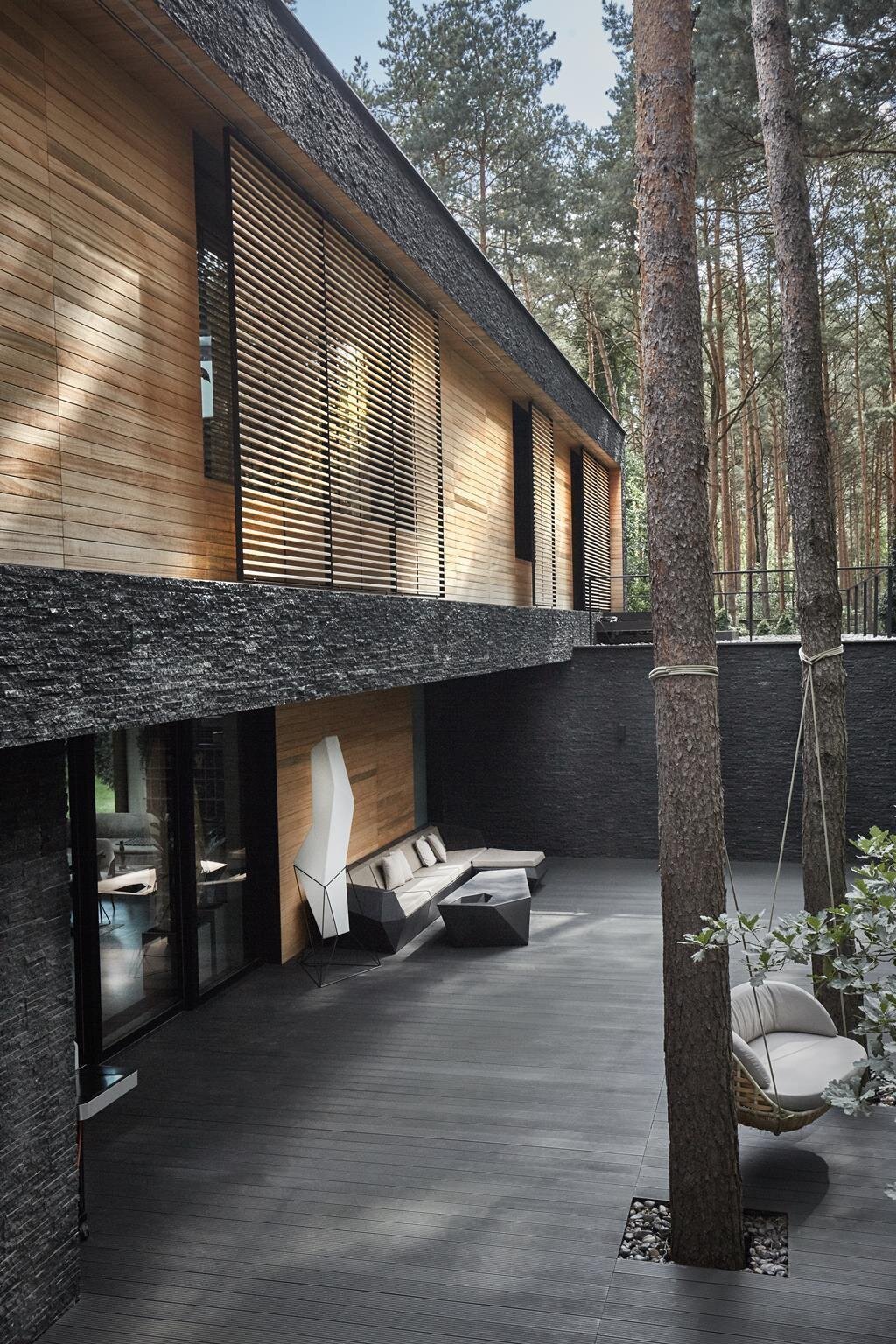 Dům s fasádou z břidlice uprostřed lesa