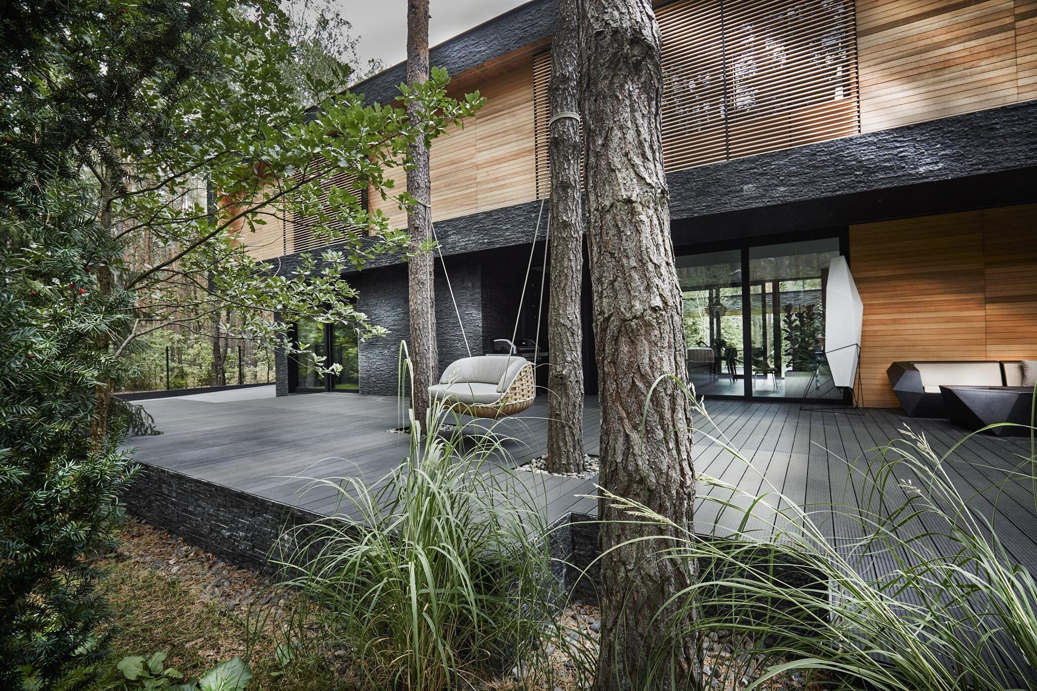 Dům s fasádou z břidlice uprostřed lesa