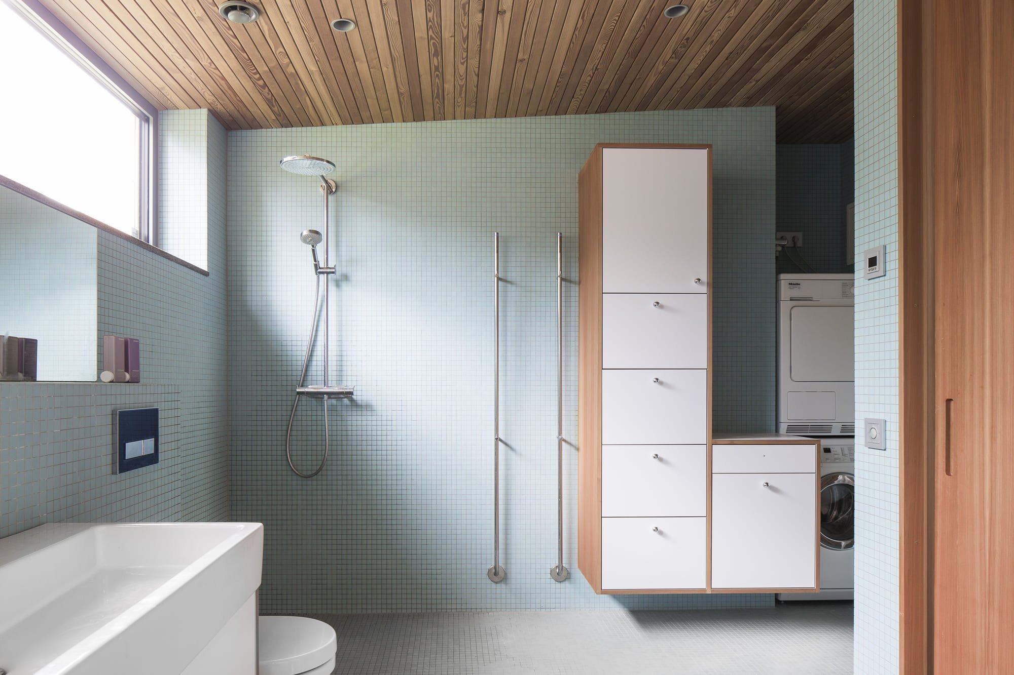 Přízemní dřevostavba mezi borovicemi a domem pro babičku