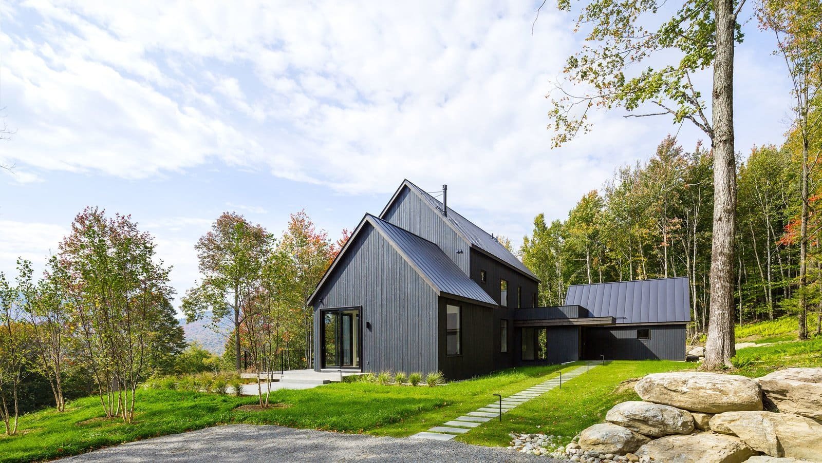 Venkovský dům na svahu obklopený lesem