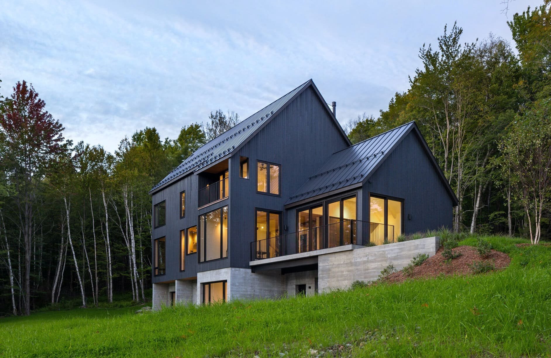 Venkovský dům na svahu obklopený lesem