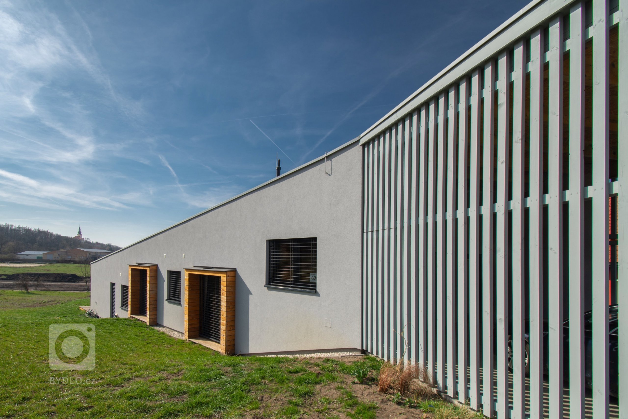 Klienty byla mladá rodina s nízkým rozpočtem a hlavním bodem zadání byl bungalov s výhledem na severozápad na České středohoří. Dům měl reagovat na terén…