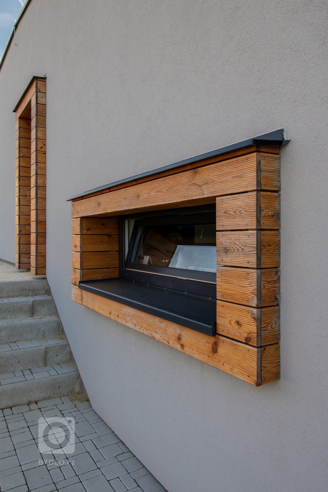 Klienty byla mladá rodina s nízkým rozpočtem a hlavním bodem zadání byl bungalov s výhledem na severozápad na České středohoří. Dům měl reagovat na terén…