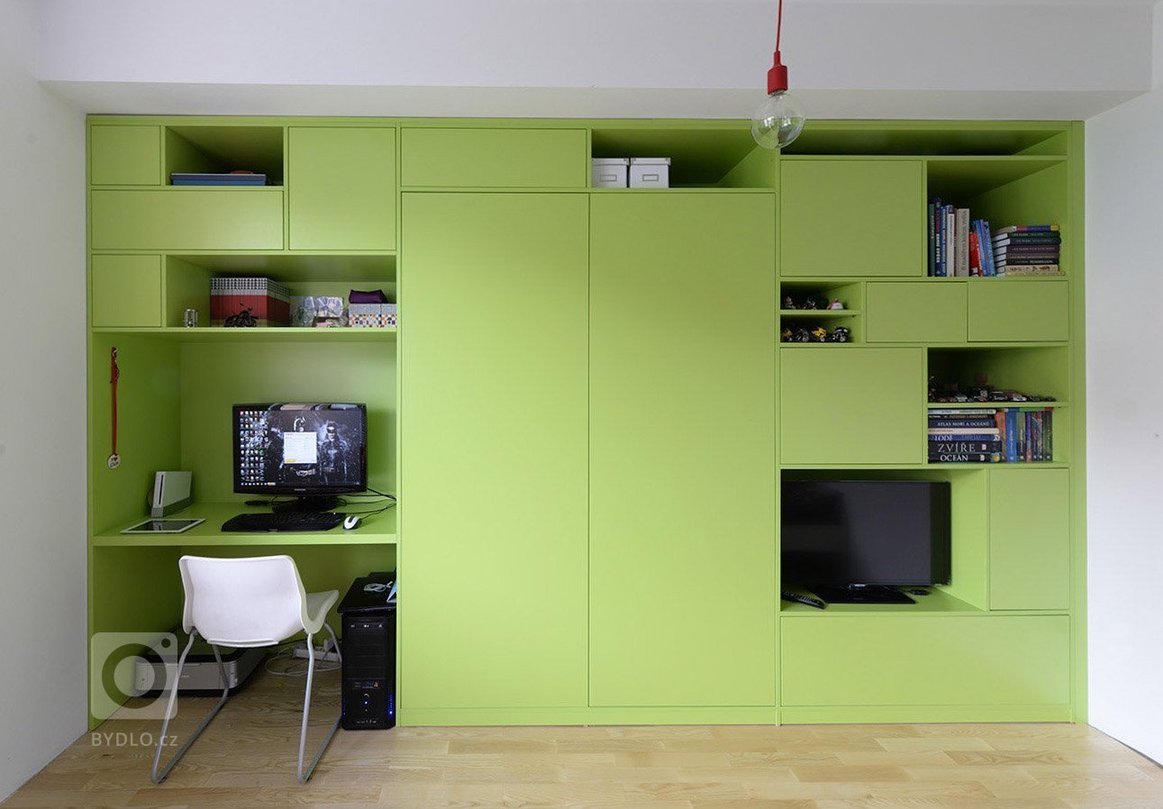 Hlavní nosnou myšlenkou je skříňová stěna, ve které se nachází veškeré úložné prostory, pracovní místo, šatní skříň, prostor pro TV a knihovna. Skříň je…