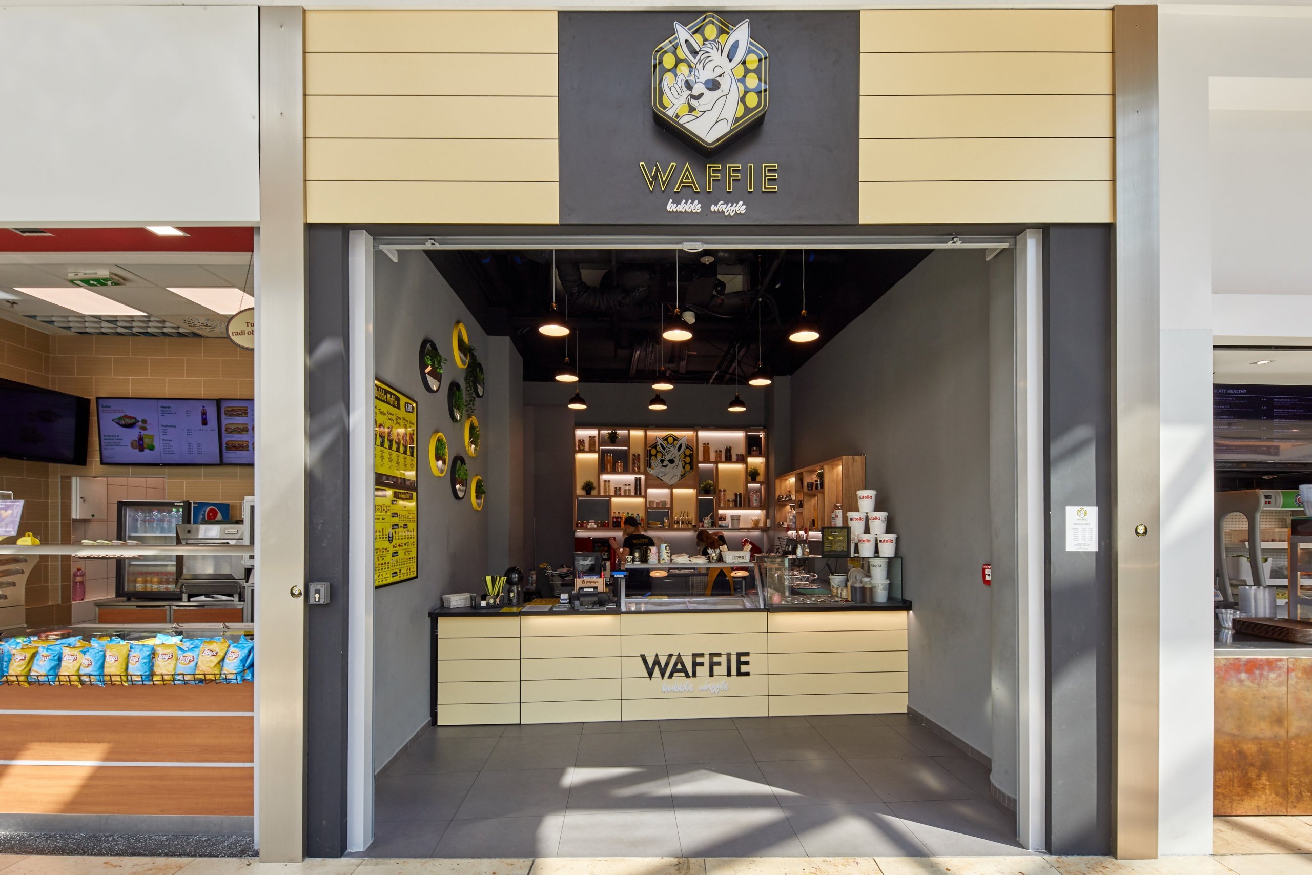 Zrealizovaný projekt prevádzky&nbsp;Waffie&nbsp;v nákupnom centre Eurovea v Bratislave. Kontrastné farebné kombinácie, doplnky, osvetlenie a samotné wafle…