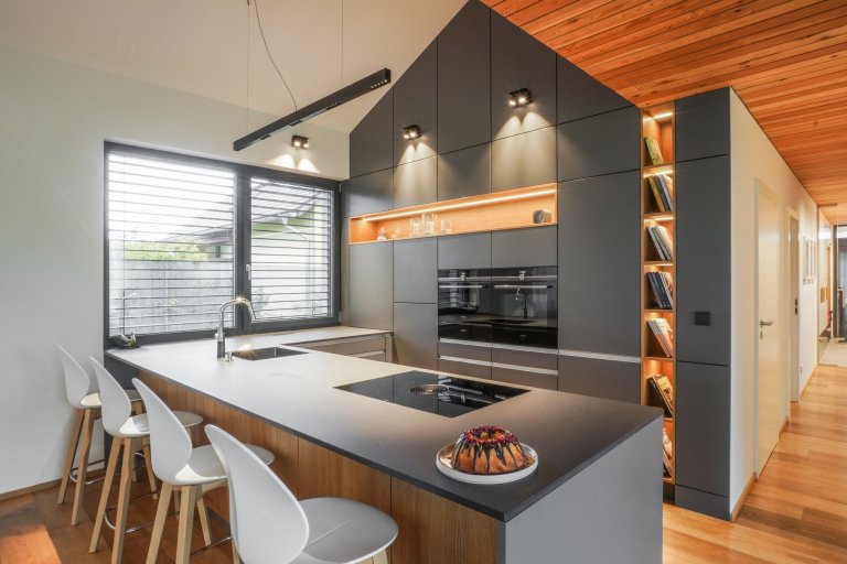 Kuchyně v moderním domě sahá až po šikmý strop