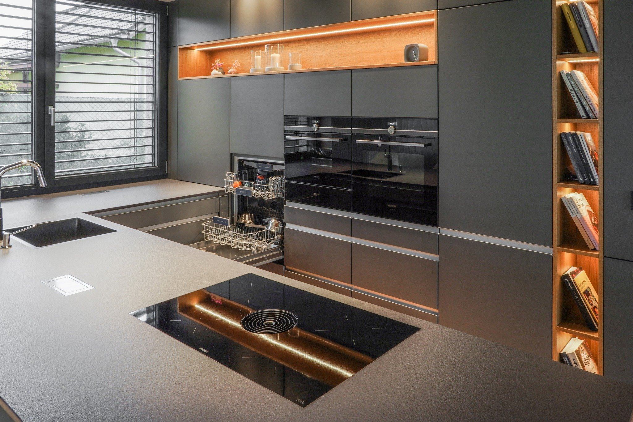 Kuchyně v moderním domě sahá až po šikmý strop