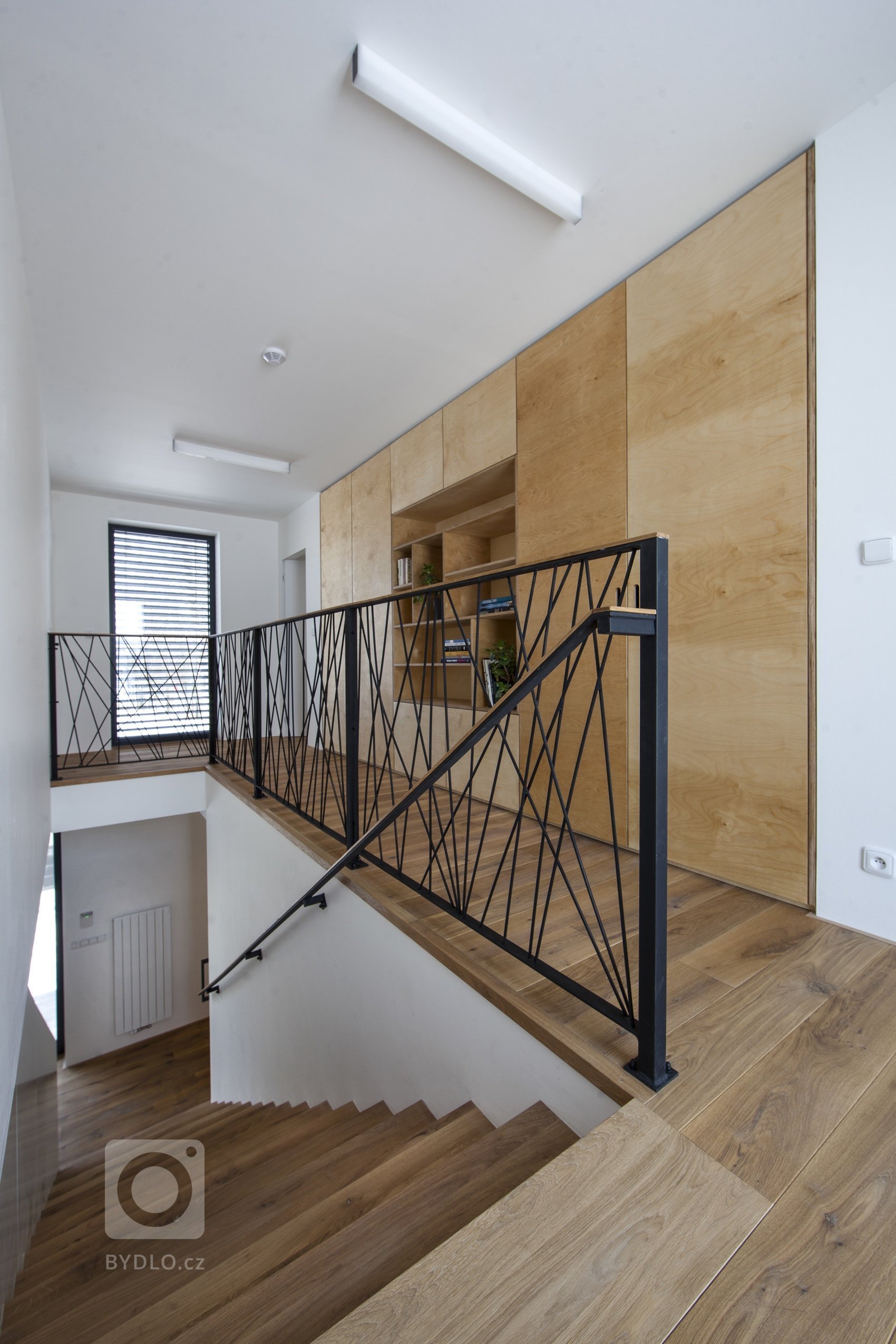 V celém domě se prolínají přírodní materiály s černými kovovými prvky a detaily s bílými stěnami a dveřmi. Industriální ráz podtrhují přiznané betonové stropy…