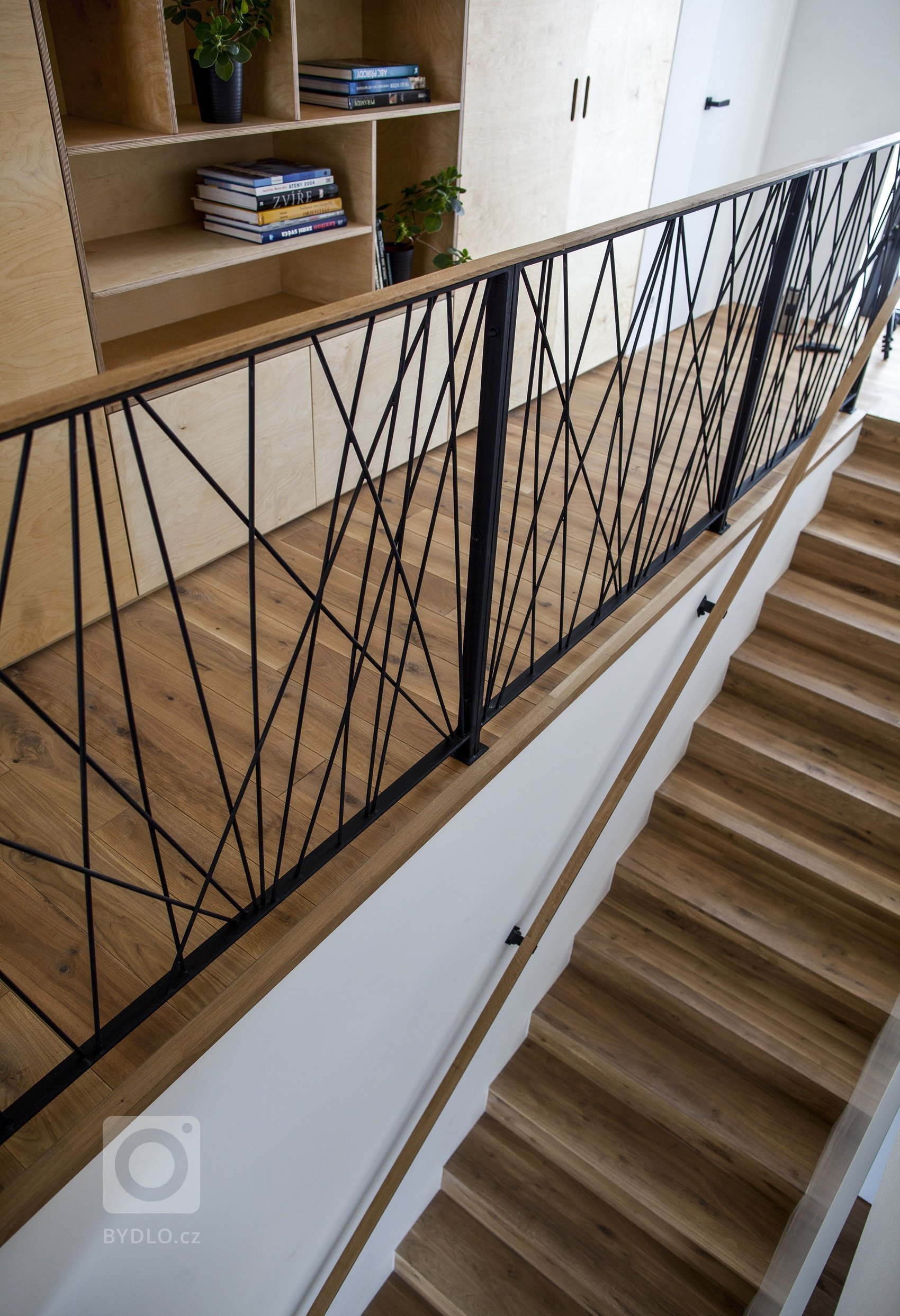 V celém domě se prolínají přírodní materiály s černými kovovými prvky a detaily s bílými stěnami a dveřmi. Industriální ráz podtrhují přiznané betonové stropy…