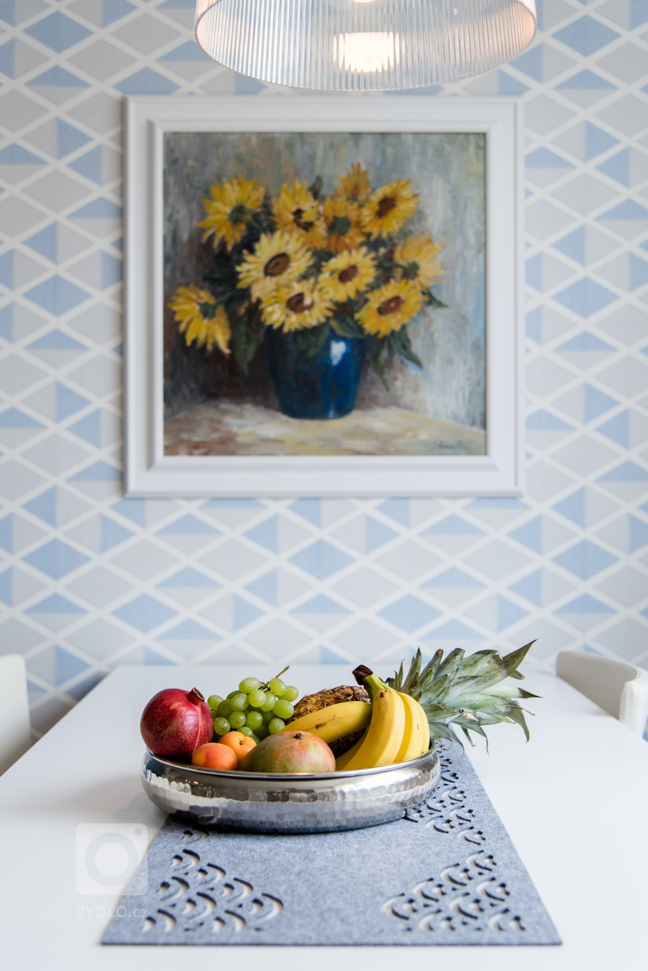 Původní velmi tmavý obývací pokoj se novým bílo-modro-béžovým laděním proměnil v příjemně světlý, svěží prostor. Výrazné tapety a koberec s pastelovými vzory…