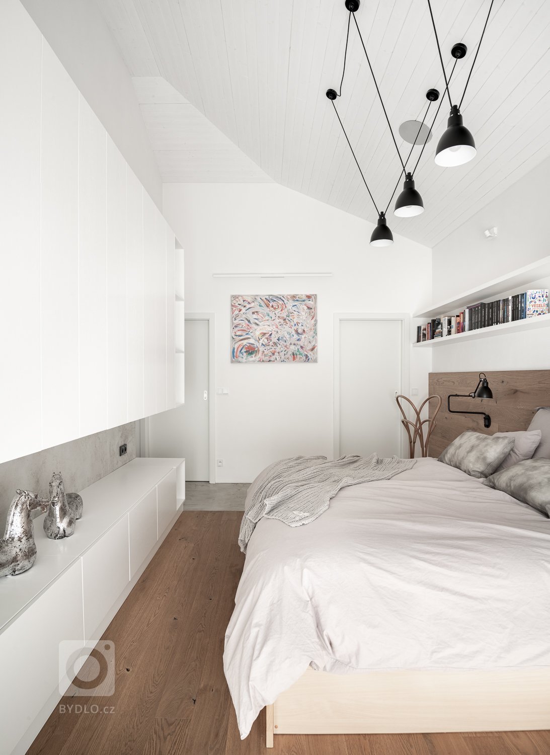 Aby bílý nábytek nesplýval se stěnou byl podtržen šedou betonovou stěrkou.