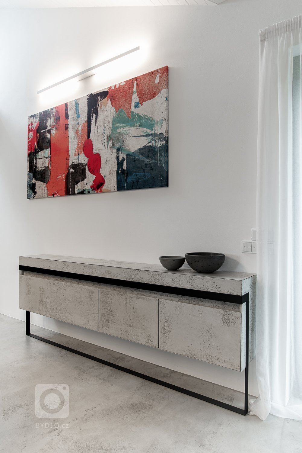 Komoda je unikátním prvkem, a to z hlediska její konstrukce a mechanismu. Byla navržena tak, aby v sobě ukrývala prostor na klíče, drobné i větší předměty a nabíjecí doky na mobil, a to vše bezdrátově. Byl kladen vysoký důraz na není její multifunkčnost, praktičnost a estetické provedení, což se bezpochyby odrazilo i na ostatním nábytku. 