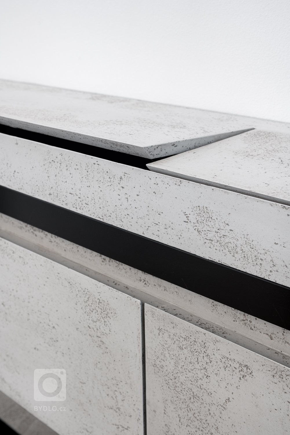 Komoda je unikátním prvkem, a to z hlediska její konstrukce a mechanismu. Byla navržena tak, aby v sobě ukrývala prostor na klíče, drobné i větší předměty a nabíjecí doky na mobil, a to vše bezdrátově. Byl kladen vysoký důraz na není její multifunkčnost, praktičnost a estetické provedení, což se bezpochyby odrazilo i na ostatním nábytku. 