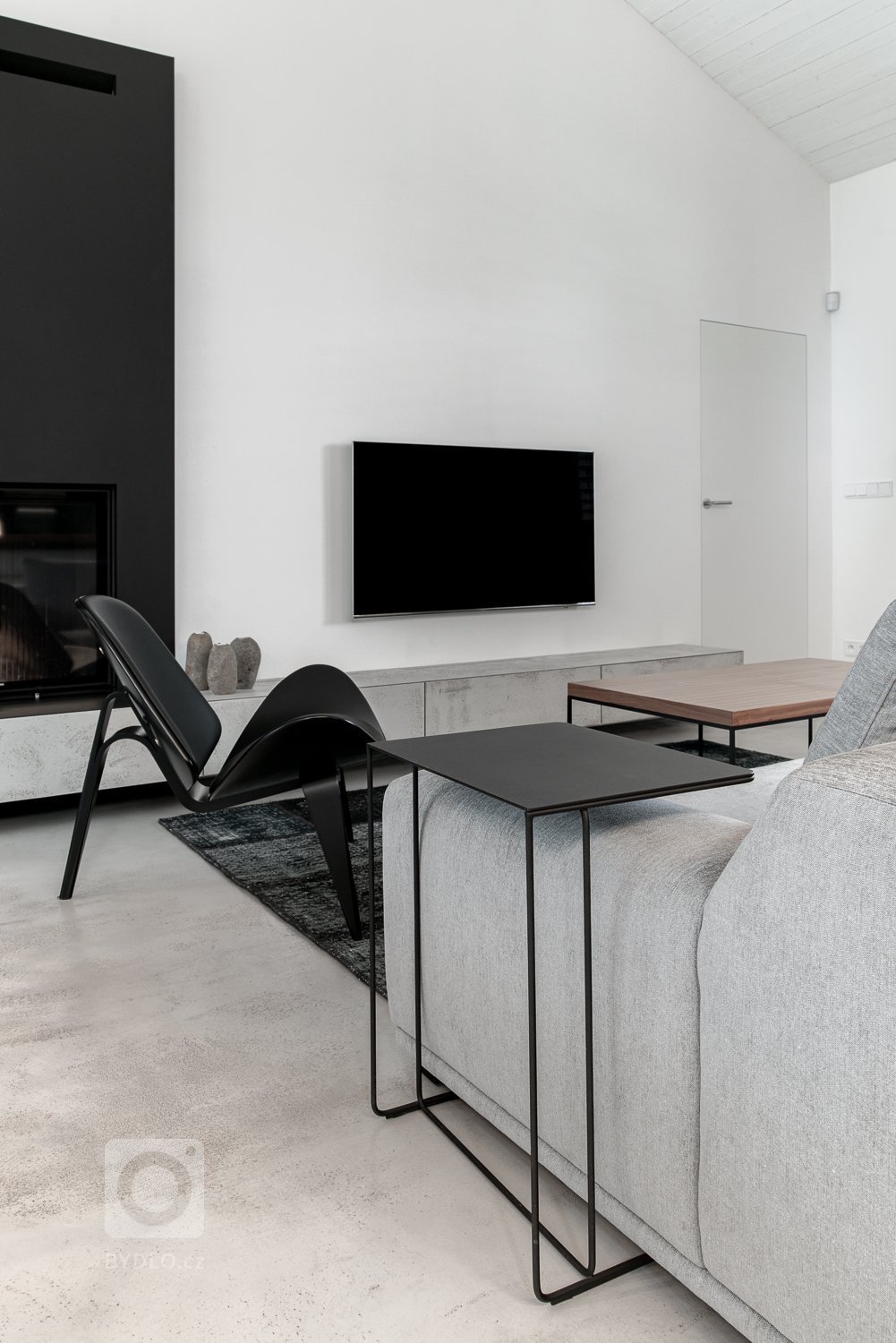 Pro vytvoření kontrastu jsme použili černé subtilní kovové prvky na kovových podnožích nábytku a osvětlení. 