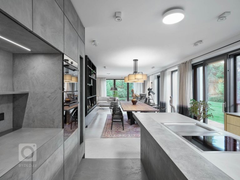 vysoká sestava kuchyňských skříněk je opatřena šedou betonovou stěrkou. Obsahuje vestavné spotřebiče a vinotéku. 