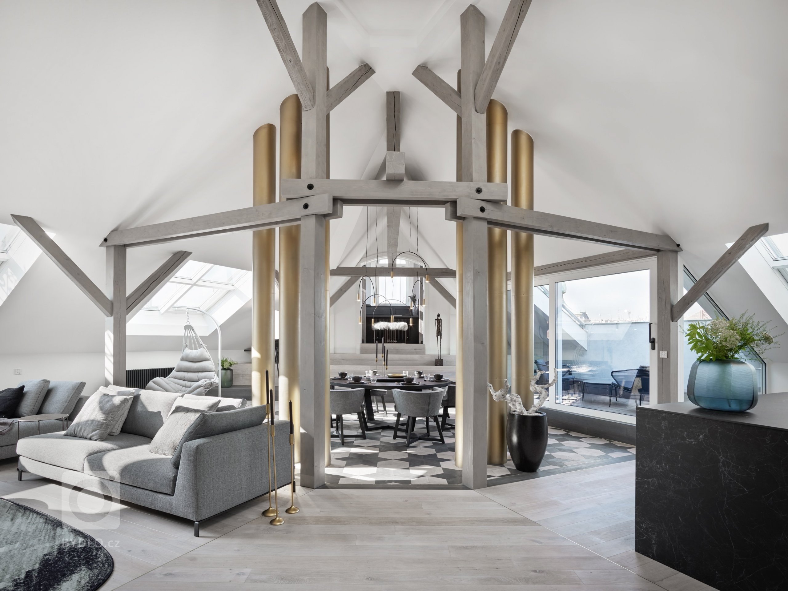 Hlavním zásahem bylo otevření zadní části bytu, přičemž se záměrně odhalilo 6 komínů, které se staly dominantou bytu. Centrálním prostorem je tedy jídelna, obývací pokoj s “relax zónou” a kuchyně s kuchyňským ostrůvkem. 