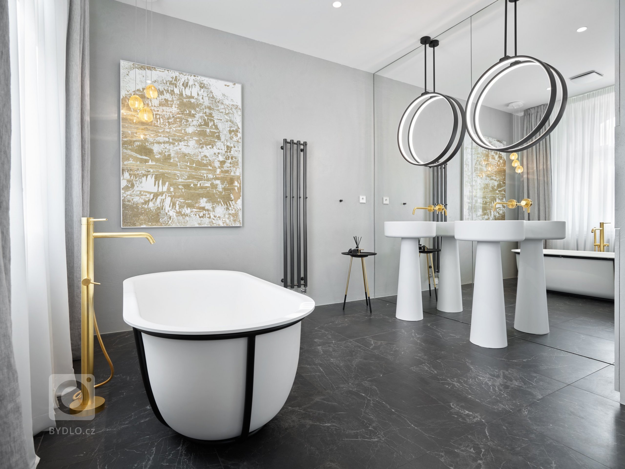 Designové kruhové osvětlení od Bulb připomíná měsíc z nebe reprezentující tapeta za postelí. Zrcadlová stěna opticky zvětšuje celou koupelnu a dodává jí patřičnou intimitu.