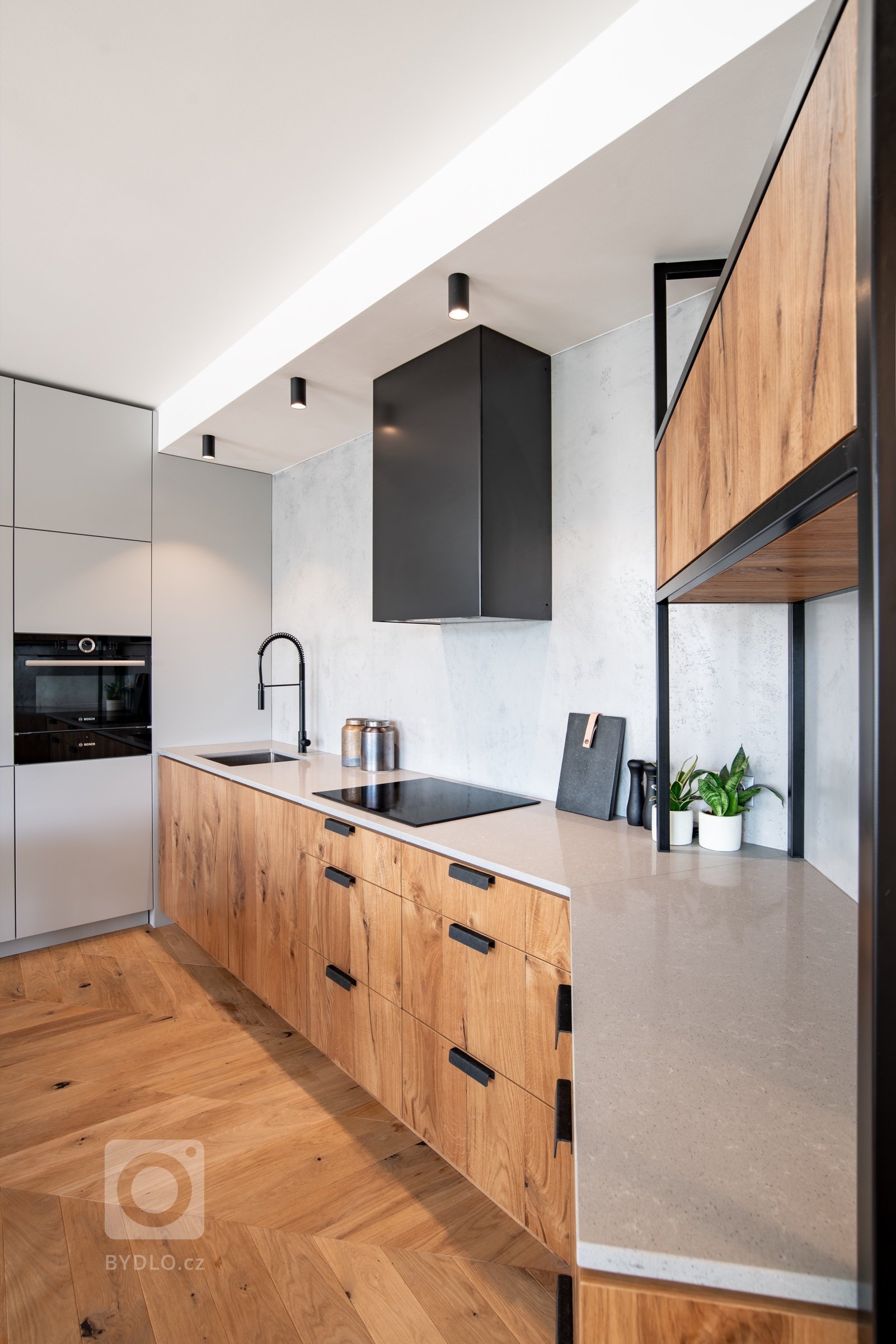 Pole působnosti dostala výrazná digestoř na betonové stěrce, která vznikla opláštěním klasické vestavné digestoře krytem z lakovaného plechu. 